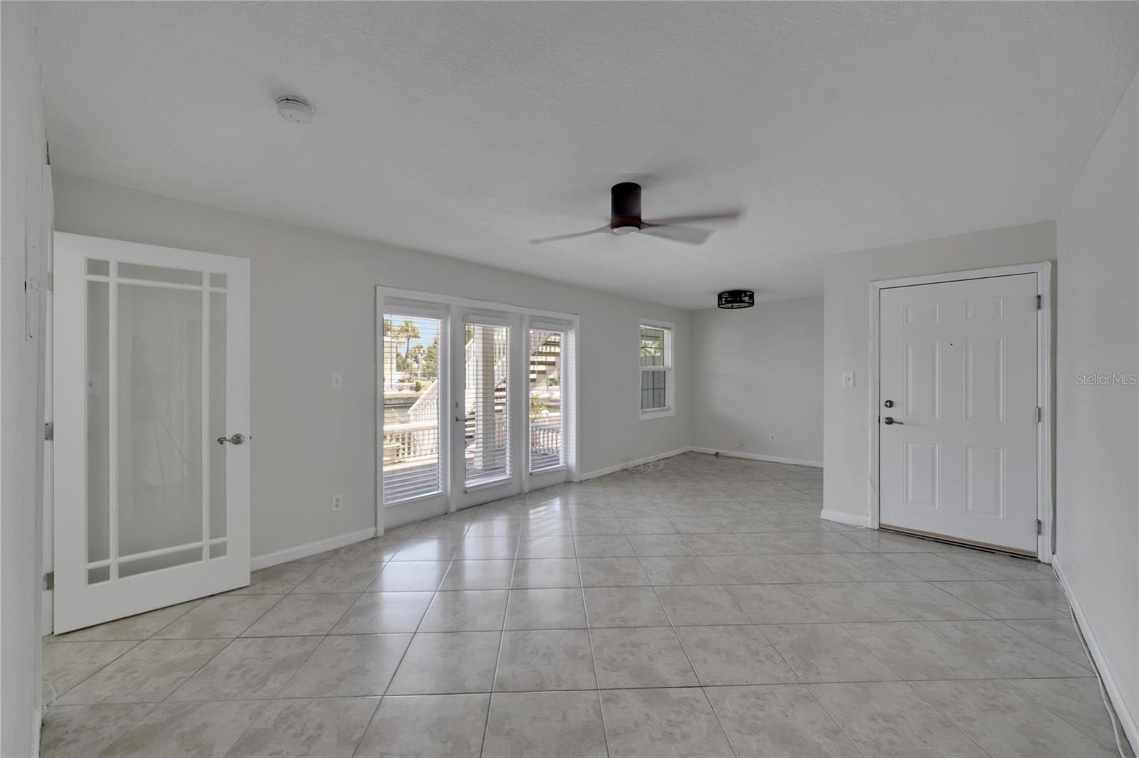 Looking from the kitchen towards front door, glass office door to your left