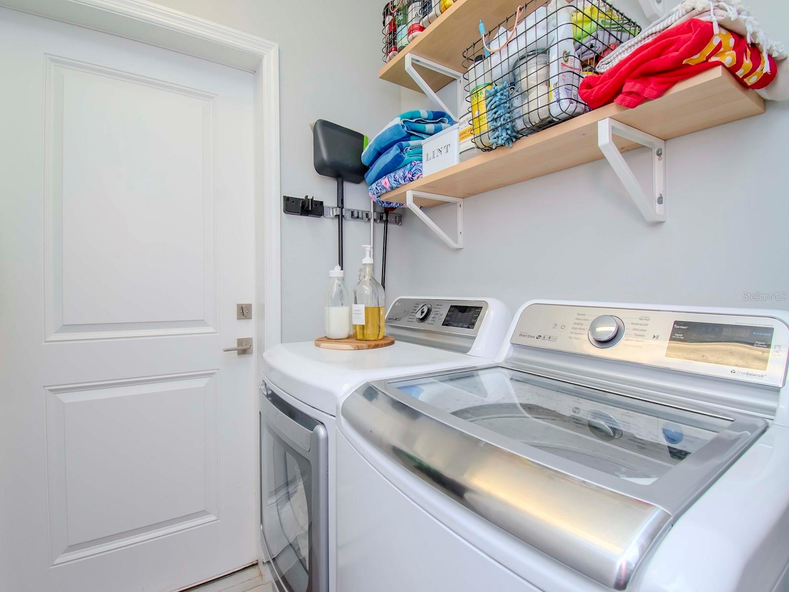 Laundry room with shelves for storage.