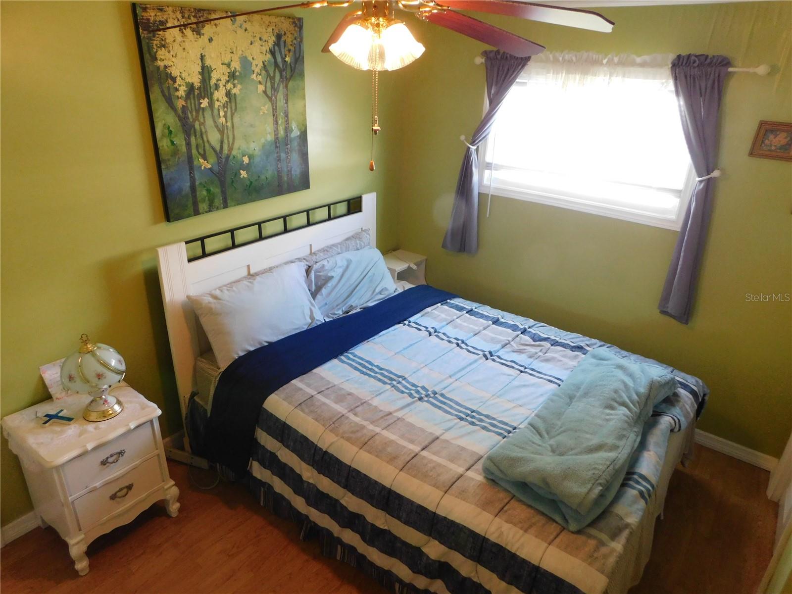 Primary bedroom has laminate flooring, ceiling fan, and double built-in closets.