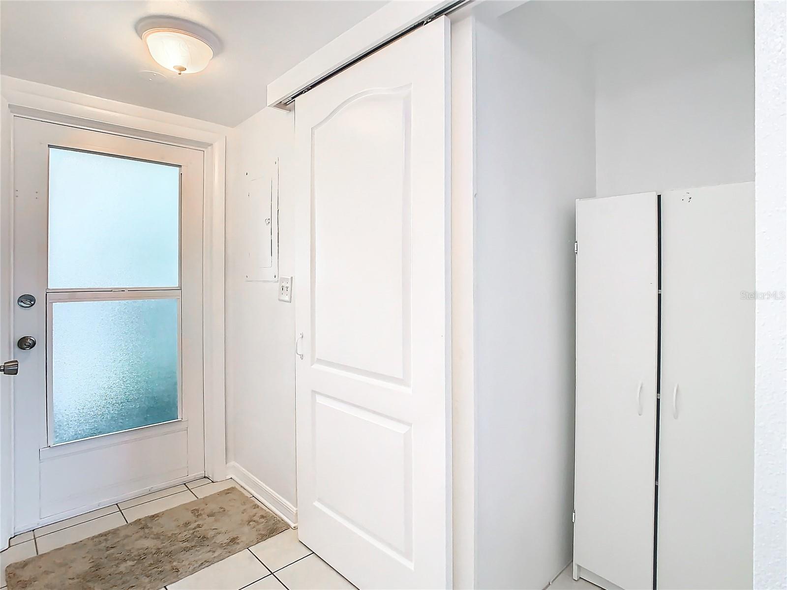 Front door (glass). Lavatory is behind the barn door.