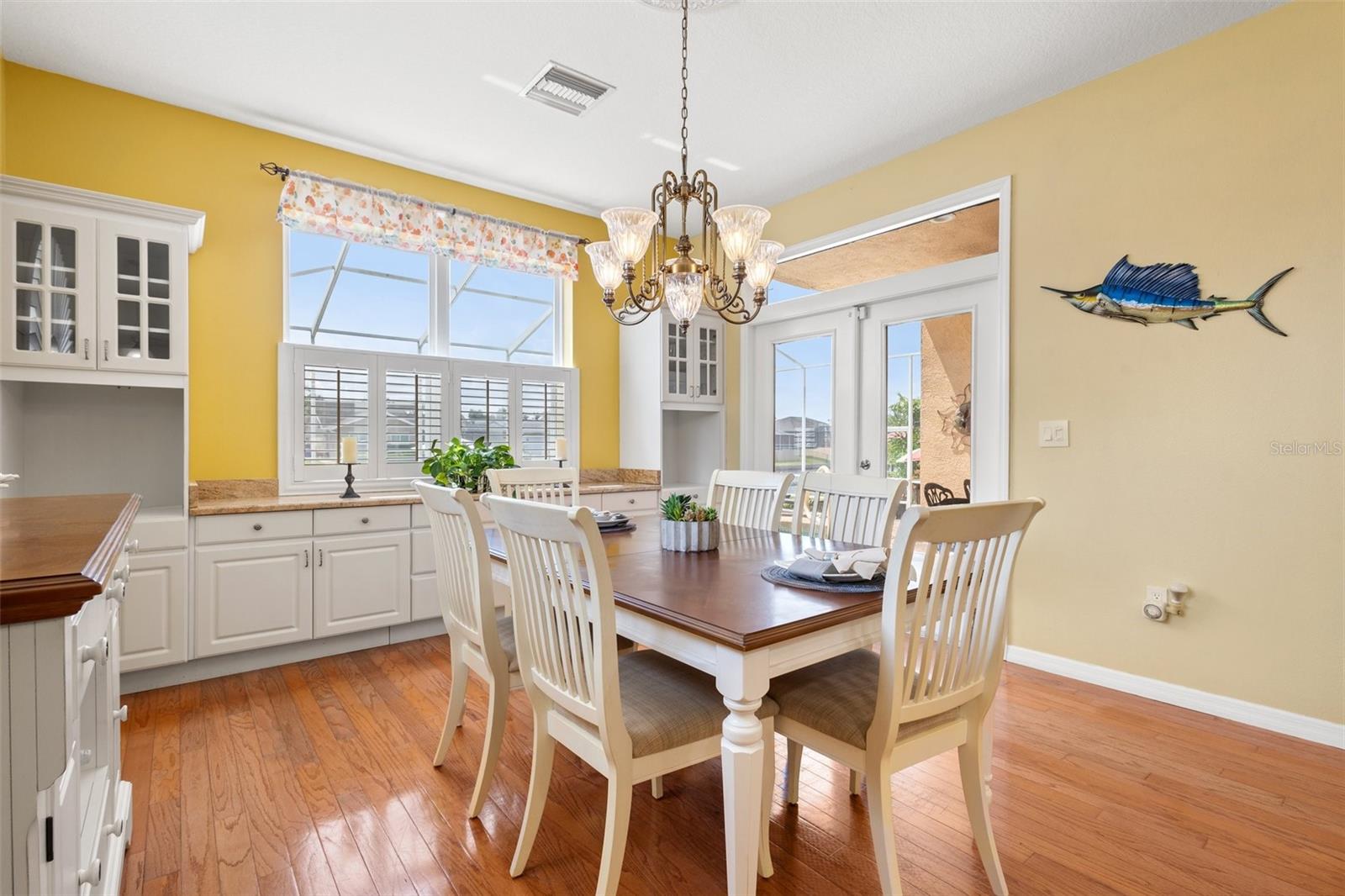 Kitchen dinette area with exit to pool, beautiful large windows letting in natural light  and hard wood floors