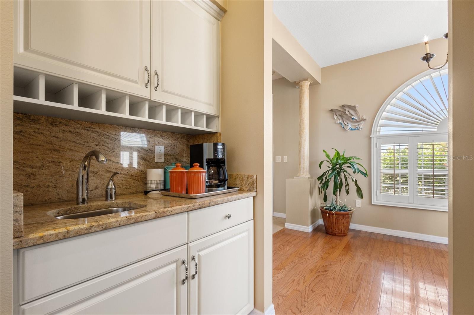 Butlers bar with built in cabinetry and granite countertops