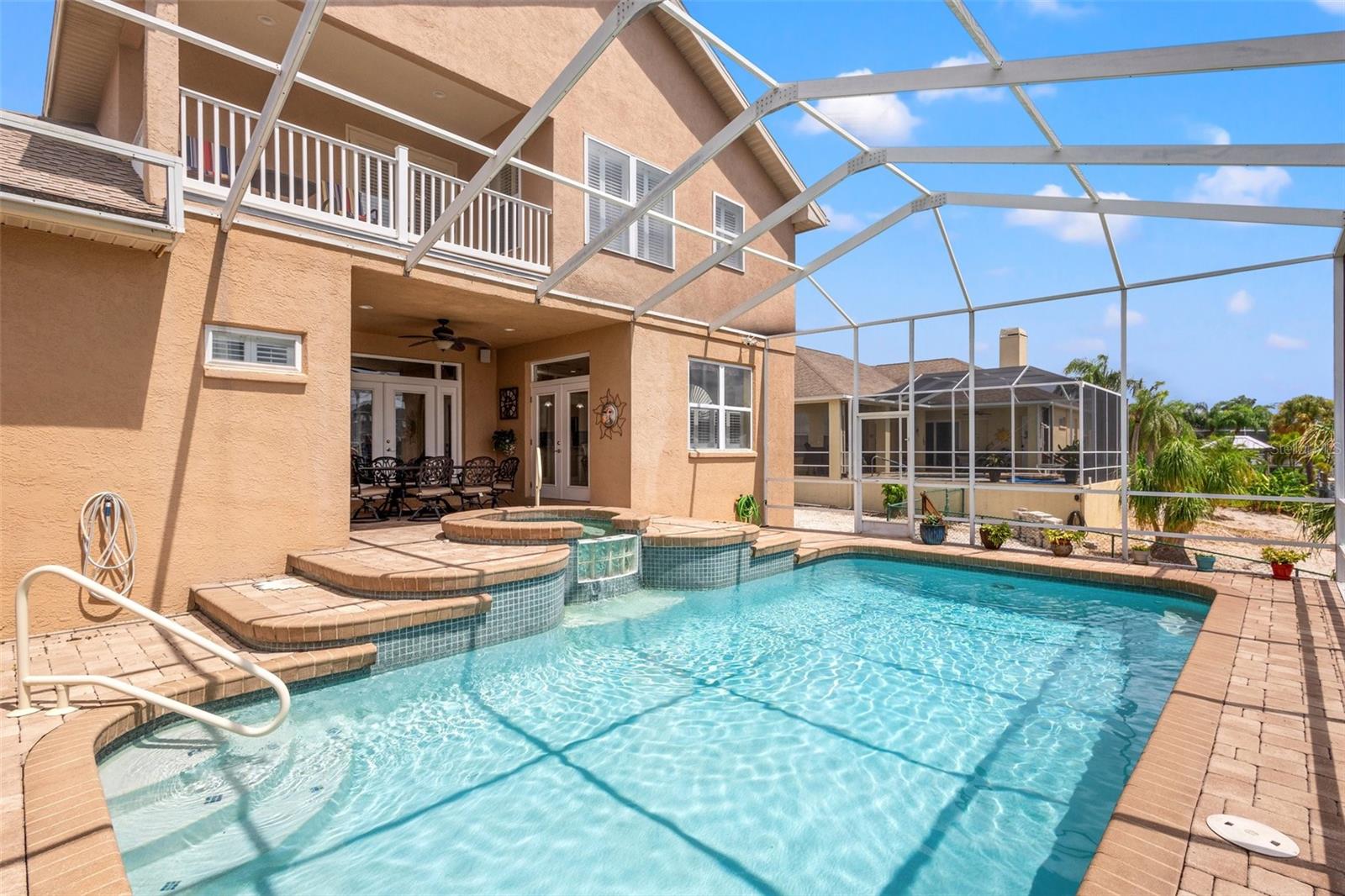 Beautiful pavers line the lanai for gorgeous views of the pebble tech pool and water