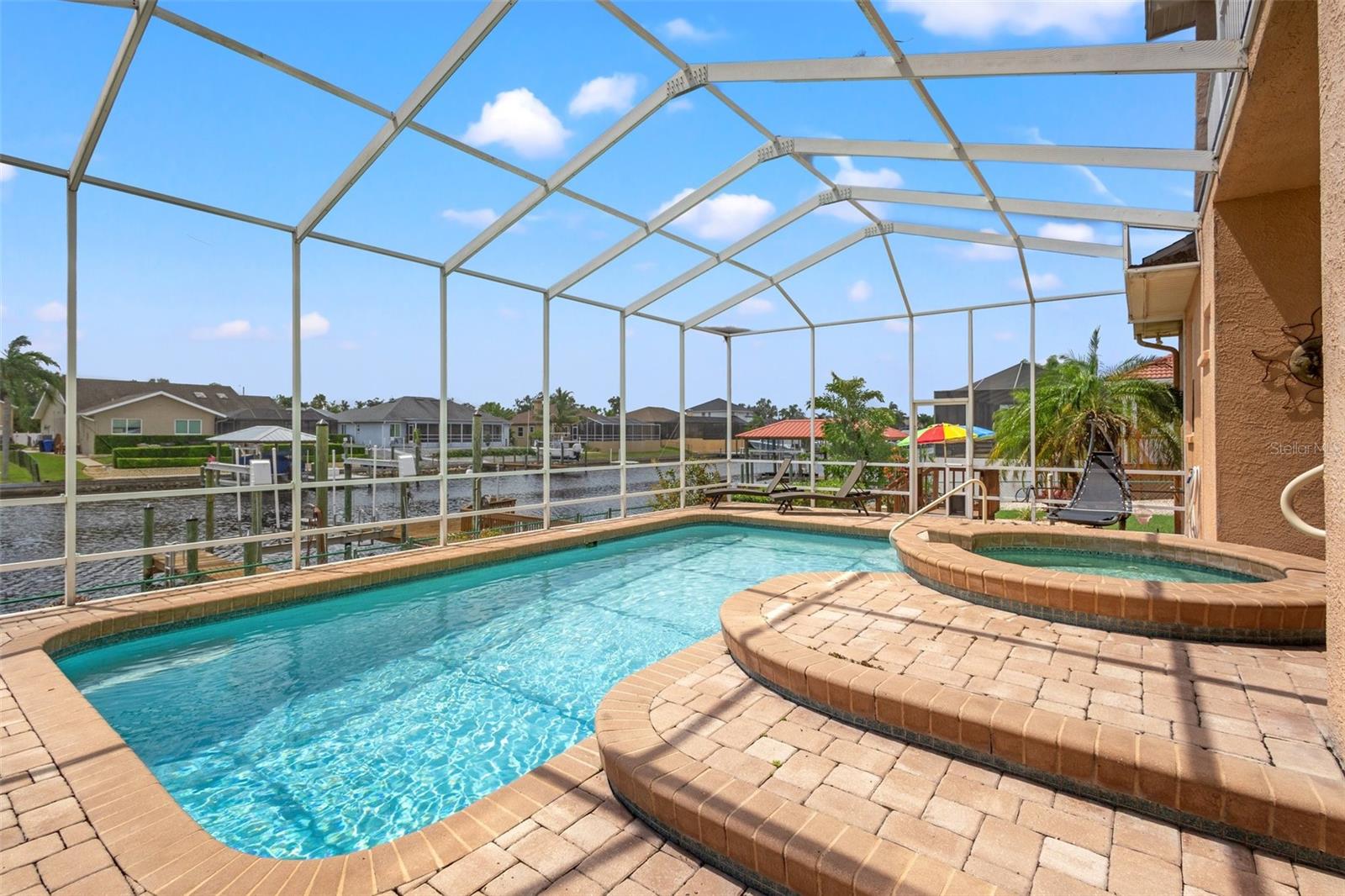 Beautiful pavers line the lanai for gorgeous views of the pebble tech pool and water