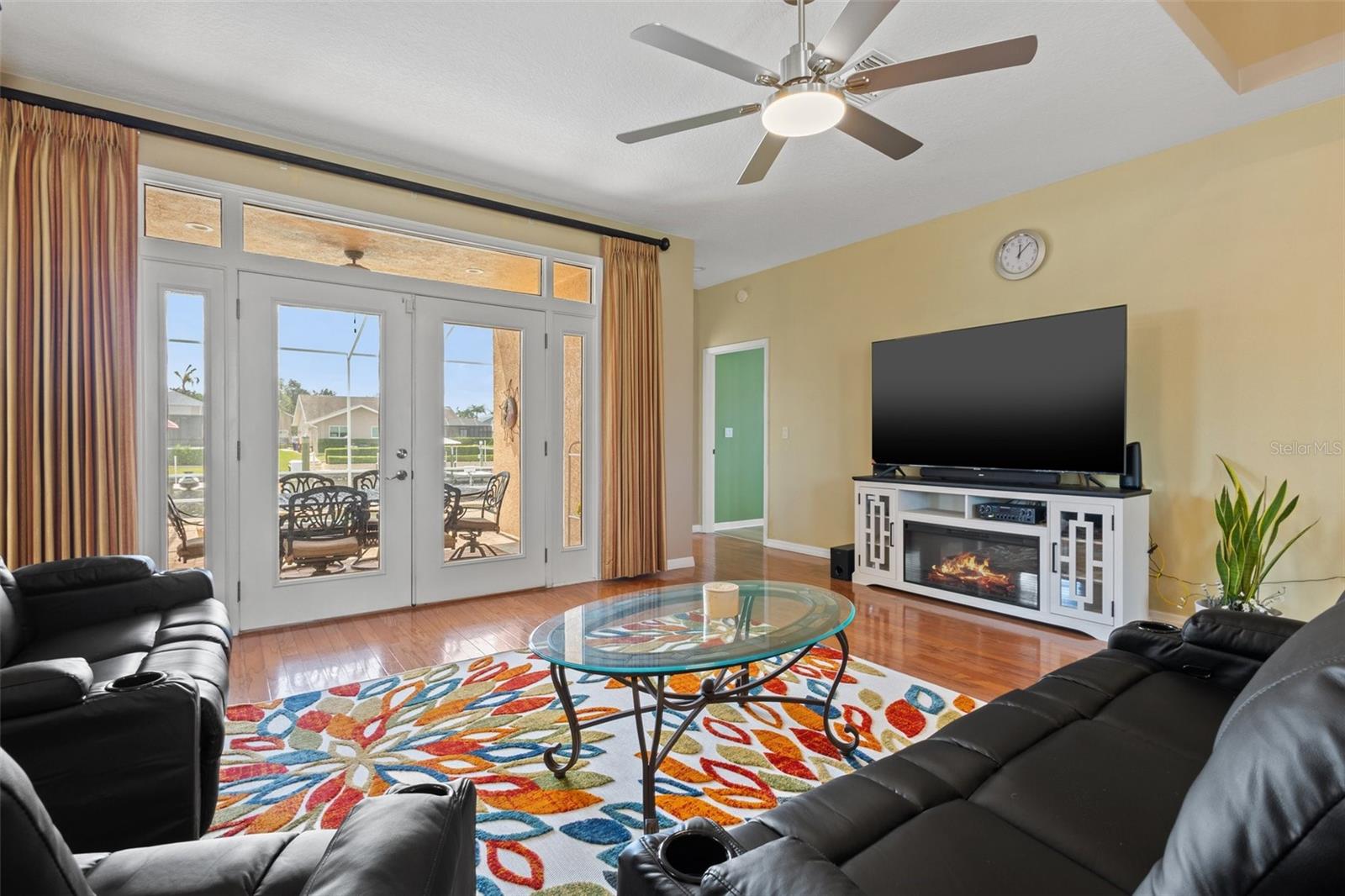 Family Room with view to the pool and water through the beautiful double glass doors.  Bedroom #2 entry on the right of the doors