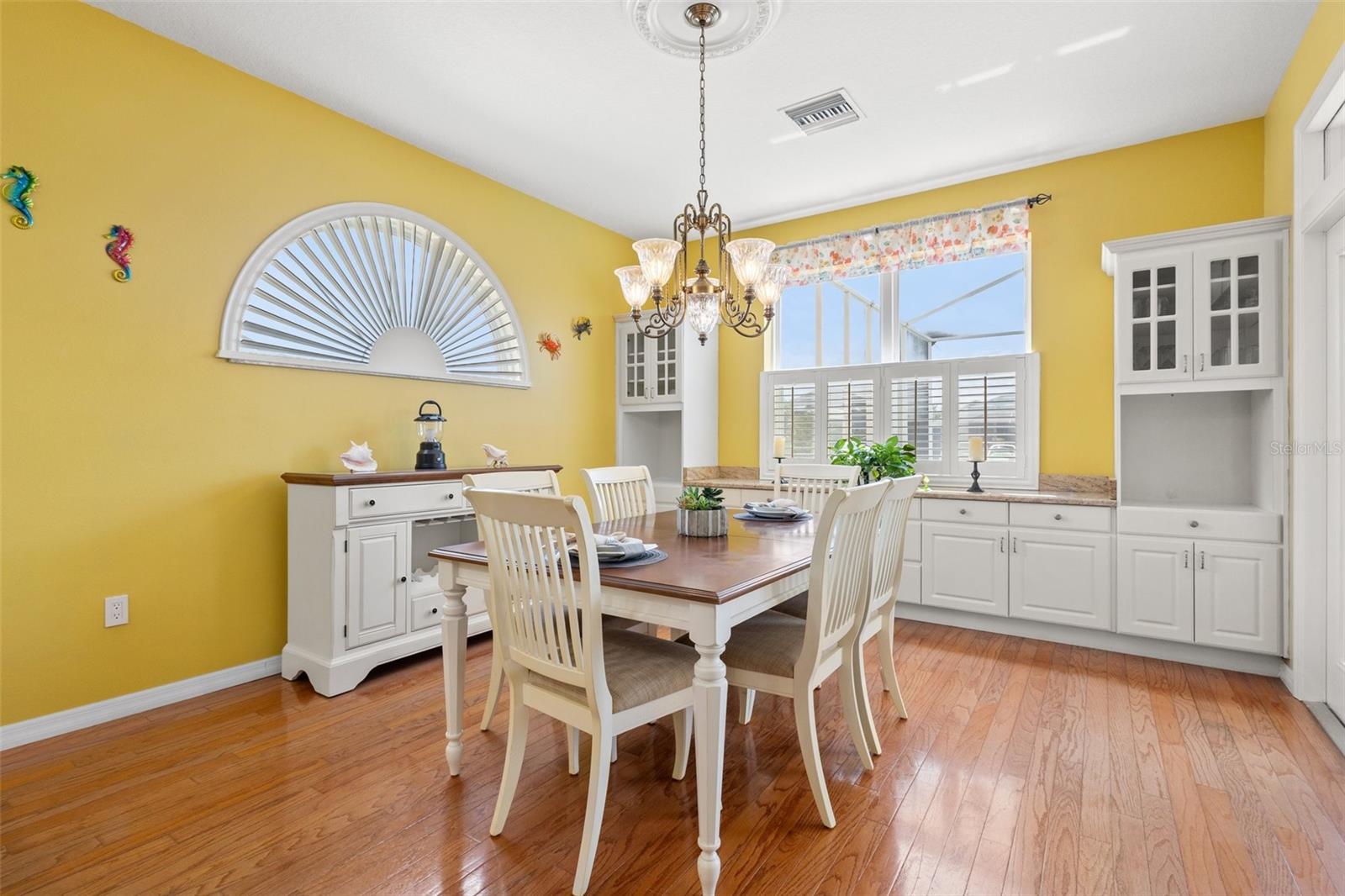 Kitchen dinette area with exit to pool, beautiful large windows letting in natural light  and hard wood floors