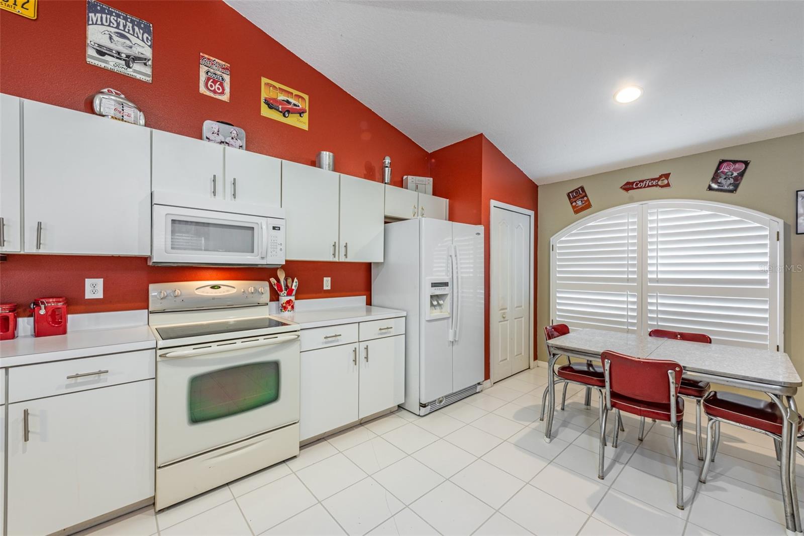 The kitchen is spacious and bright with a cathedral ceiling and custom plantation shutters on a large window overlooking the front yard.