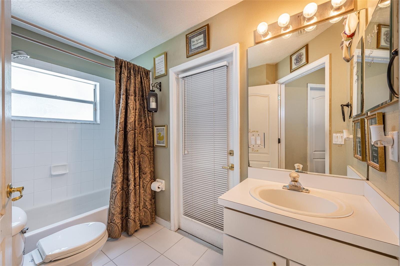 Full bathroom #2 with exterior door leading to enclosed back porch.