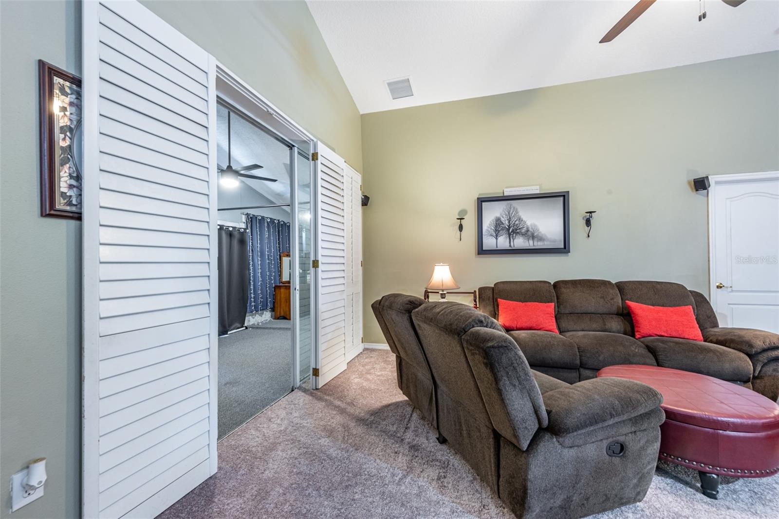 Family room sliding door adorned with plantation shutters leads to enclosed back porch.