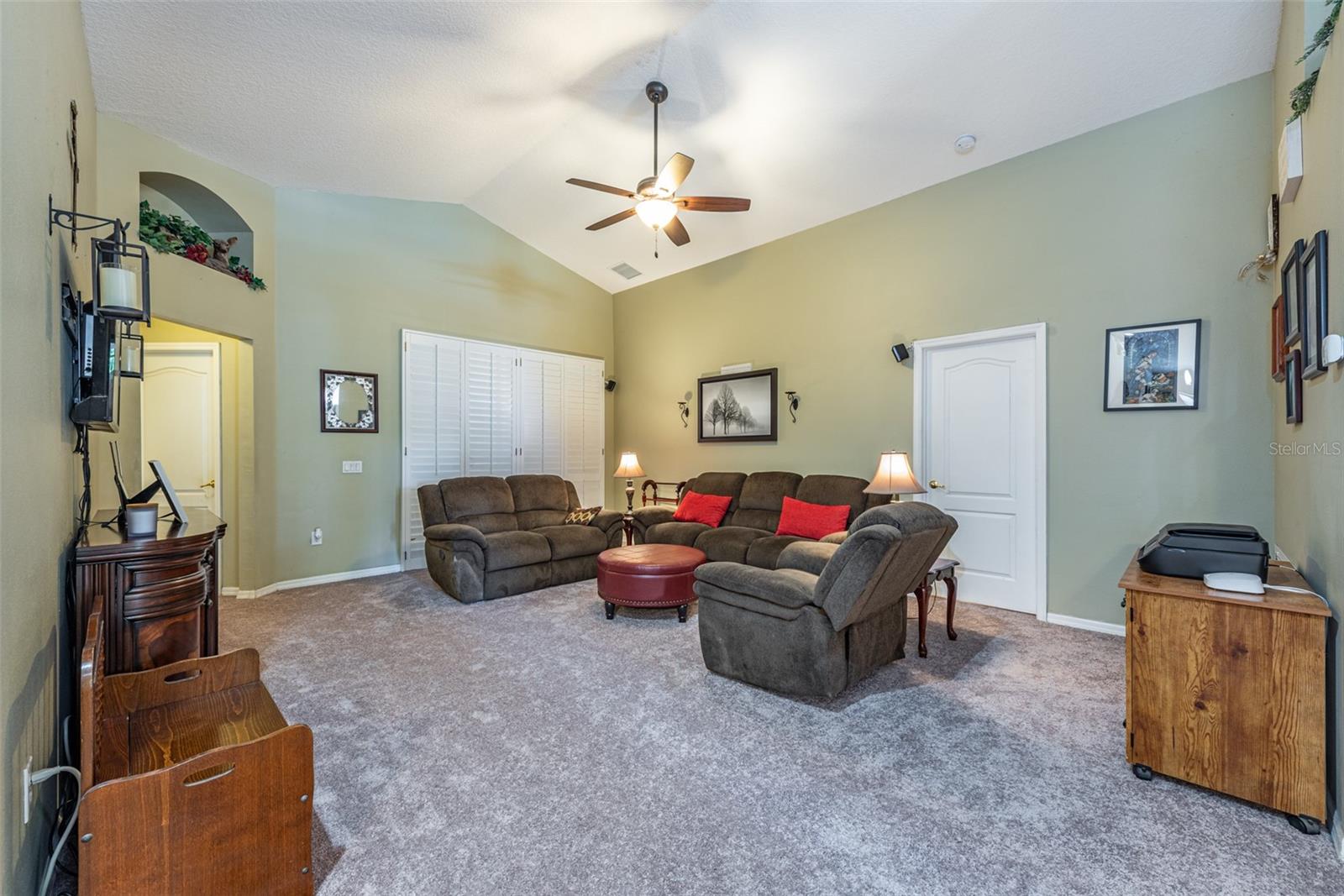 The Family room has a cathedral ceiling with fan and plantation shutters cover the entrance to the enclosed back porch.  Carpet just installed August 2024!