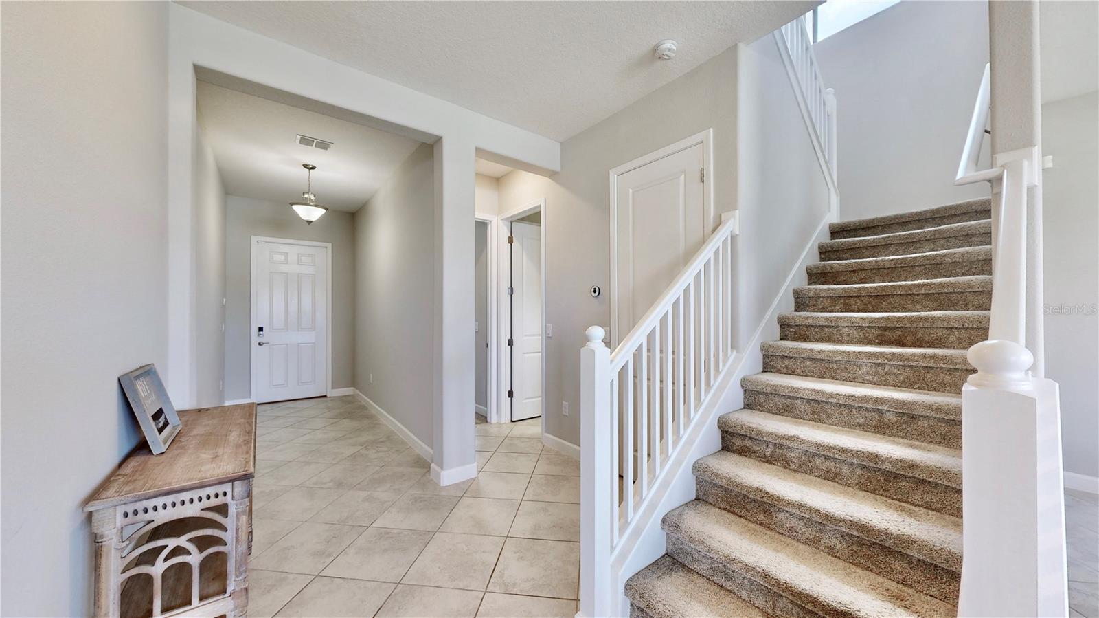 bottom of staircase back to entry and downstairs bedroom/bathroom