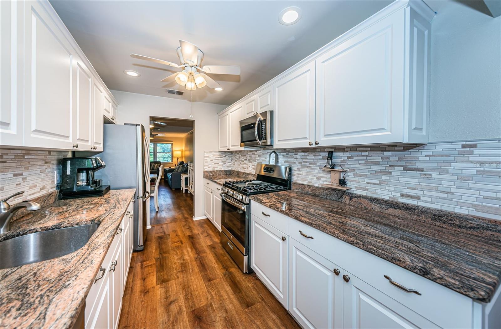 Perfectly updated and modern kitchen with granite countertops, modern appliances and a gas stove.