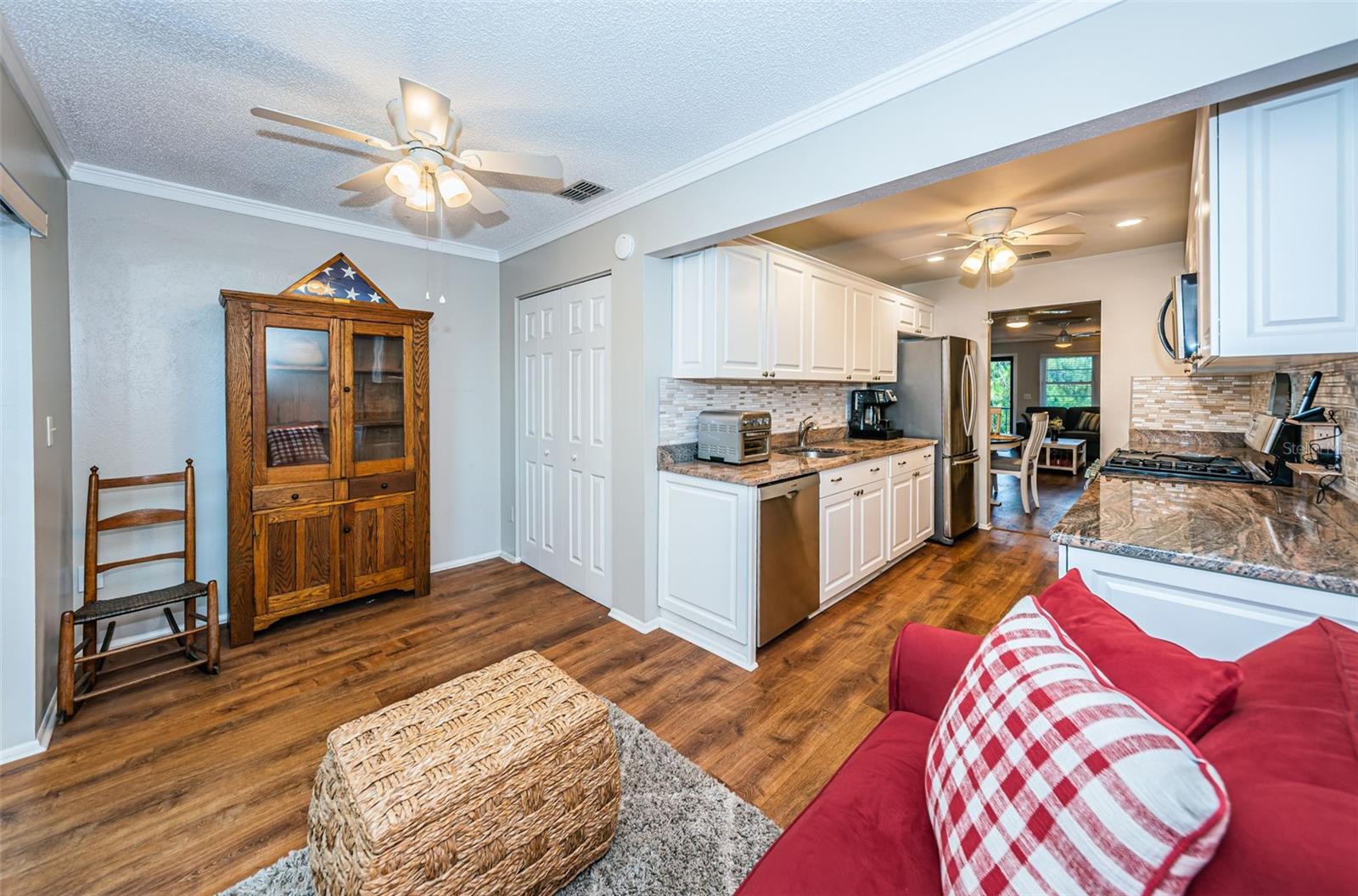 In between the outdoor screened porch and the kitchen, you will find a bonus room currently used as a second sitting area. The red loveseat has a pull out sleeper bed.