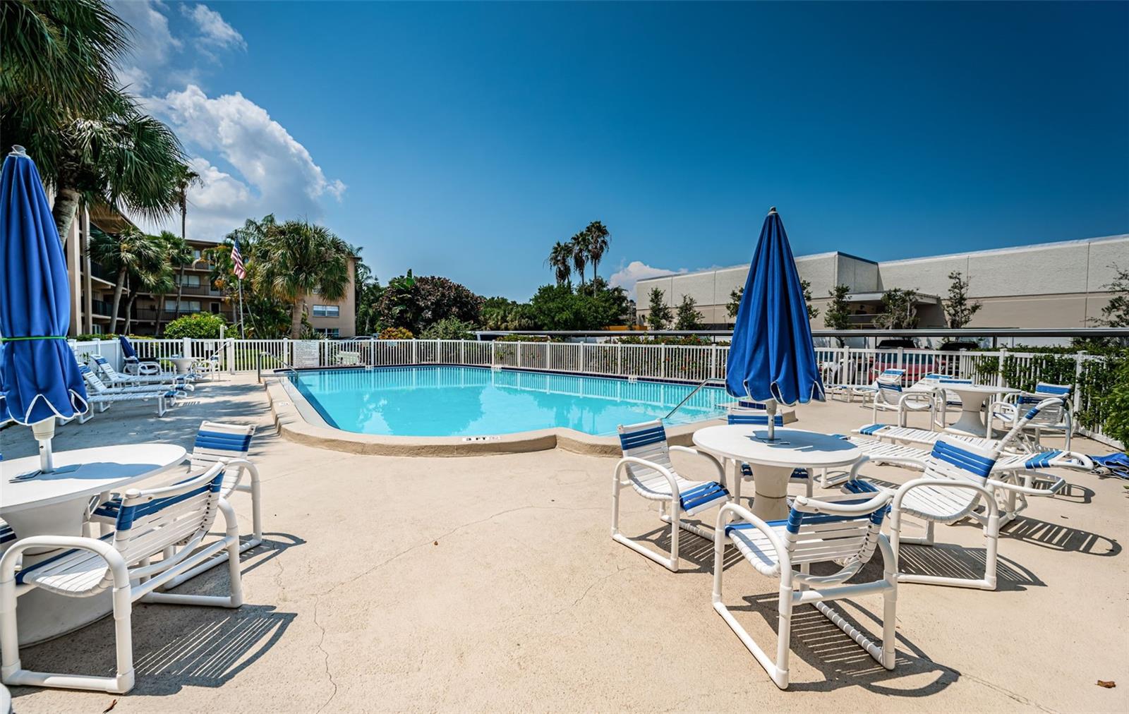 Enjoy the pool area with ample seating, including lounge chairs, a stylish table, and a large umbrella to provide shade and comfort.