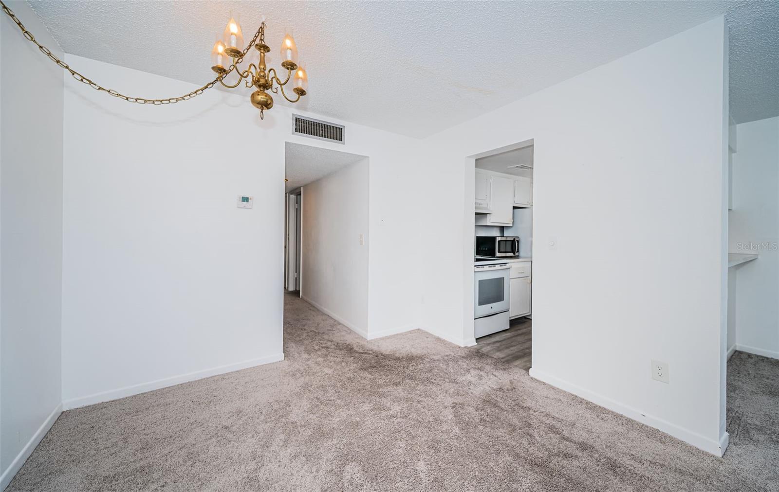 The dining room opens up to the kitchen area, offering a cohesive layout that blends both spaces for a functional and stylish living environment.