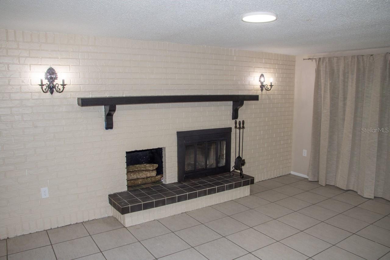 WOOD BURNING FIRE PLACE AND MANTEL IN FAMILY ROOM