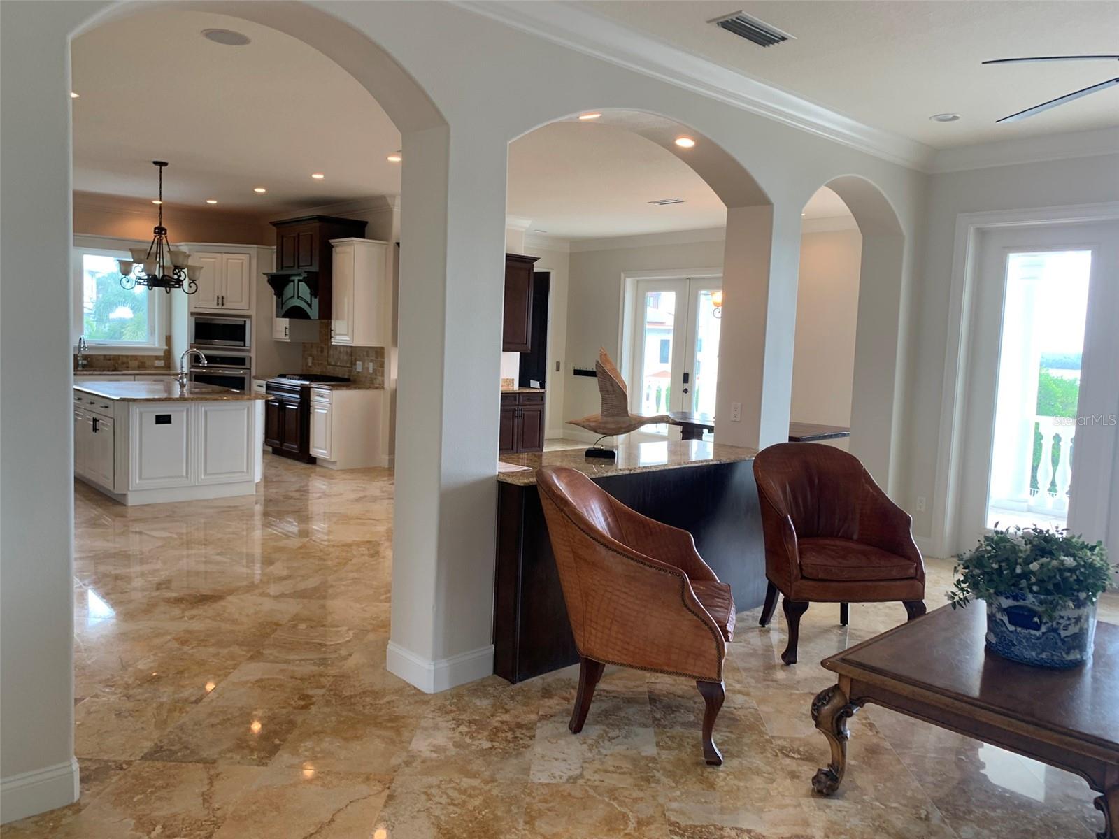 Coved archways separating kitchen area from great room