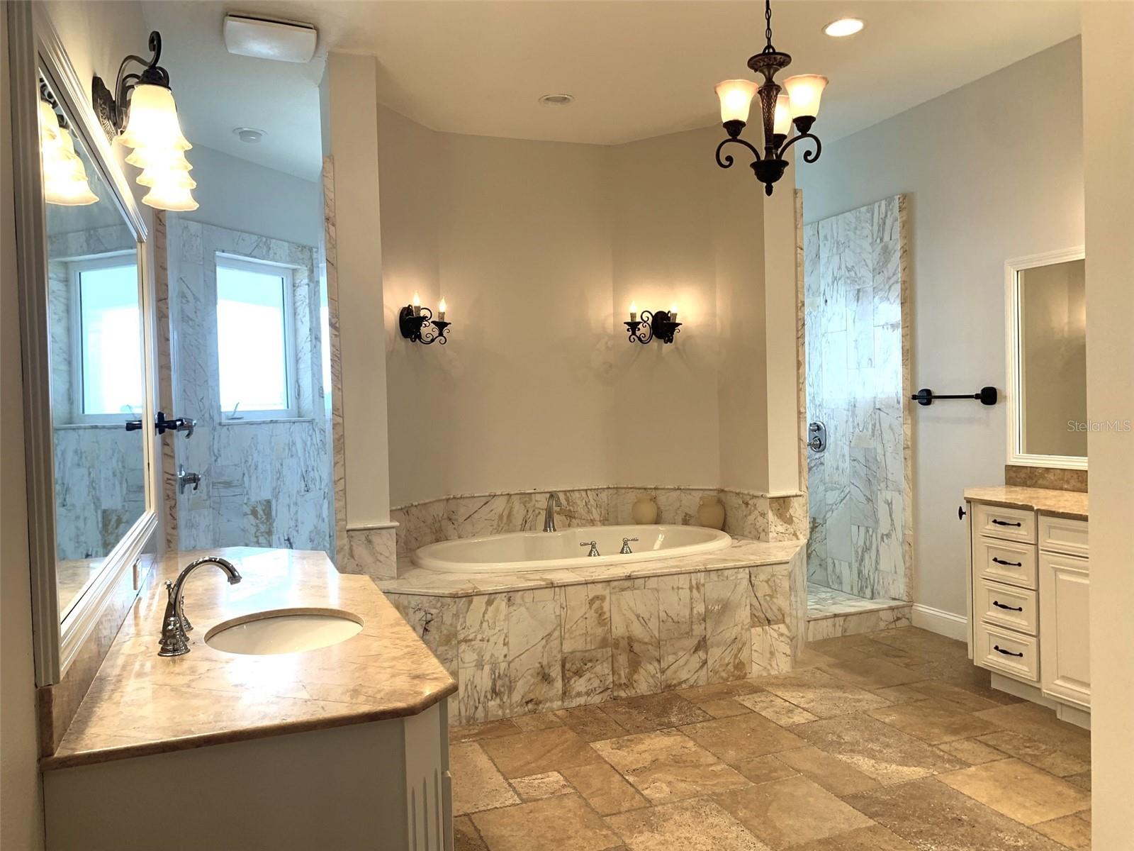 Primary Bath with two vanities, expansive walk thru shower, separate tub and private toilet area.