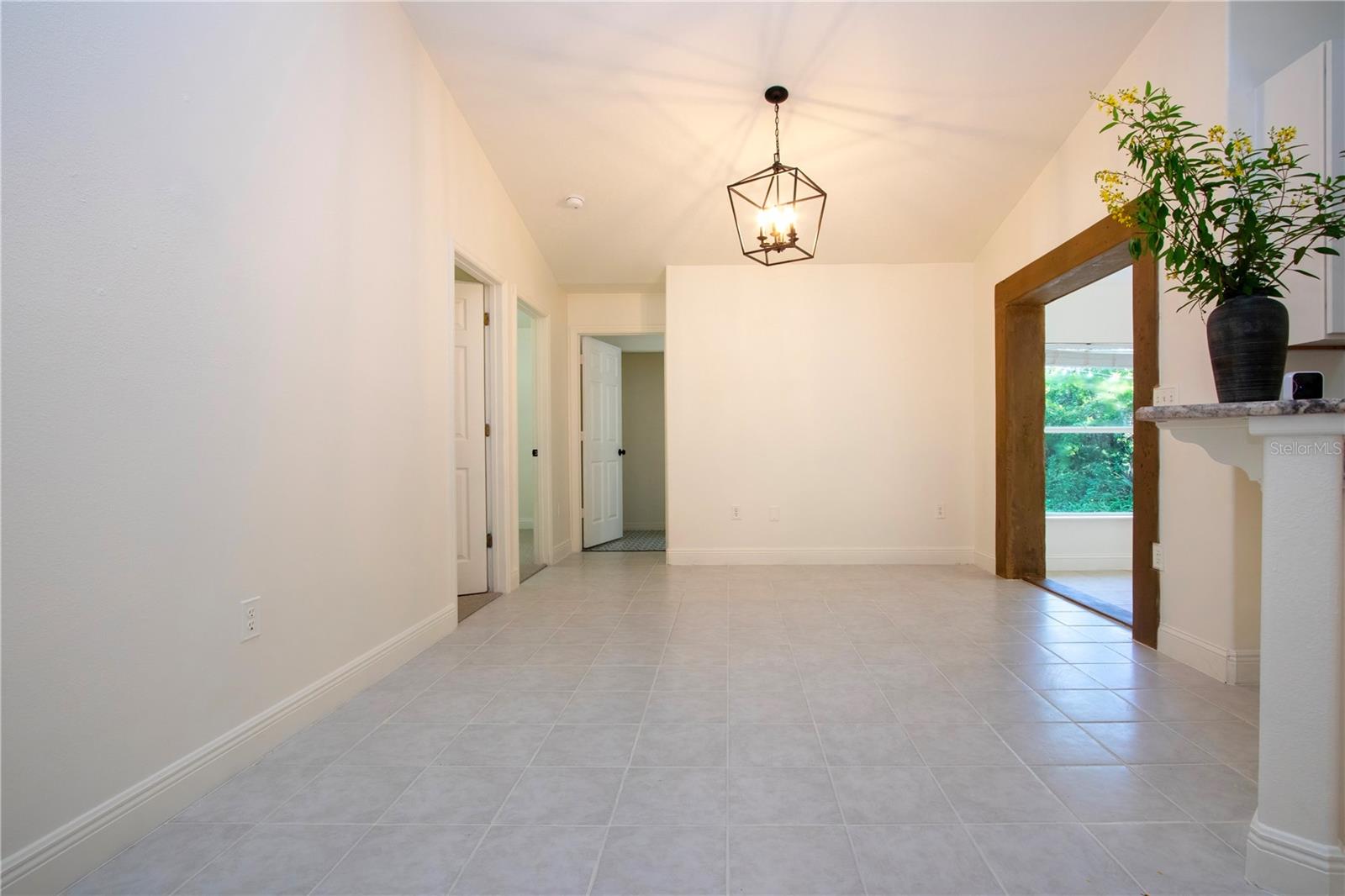 View of living room showing fresh cut flowers from the garden and a second entry to the enclosed under air Florida room