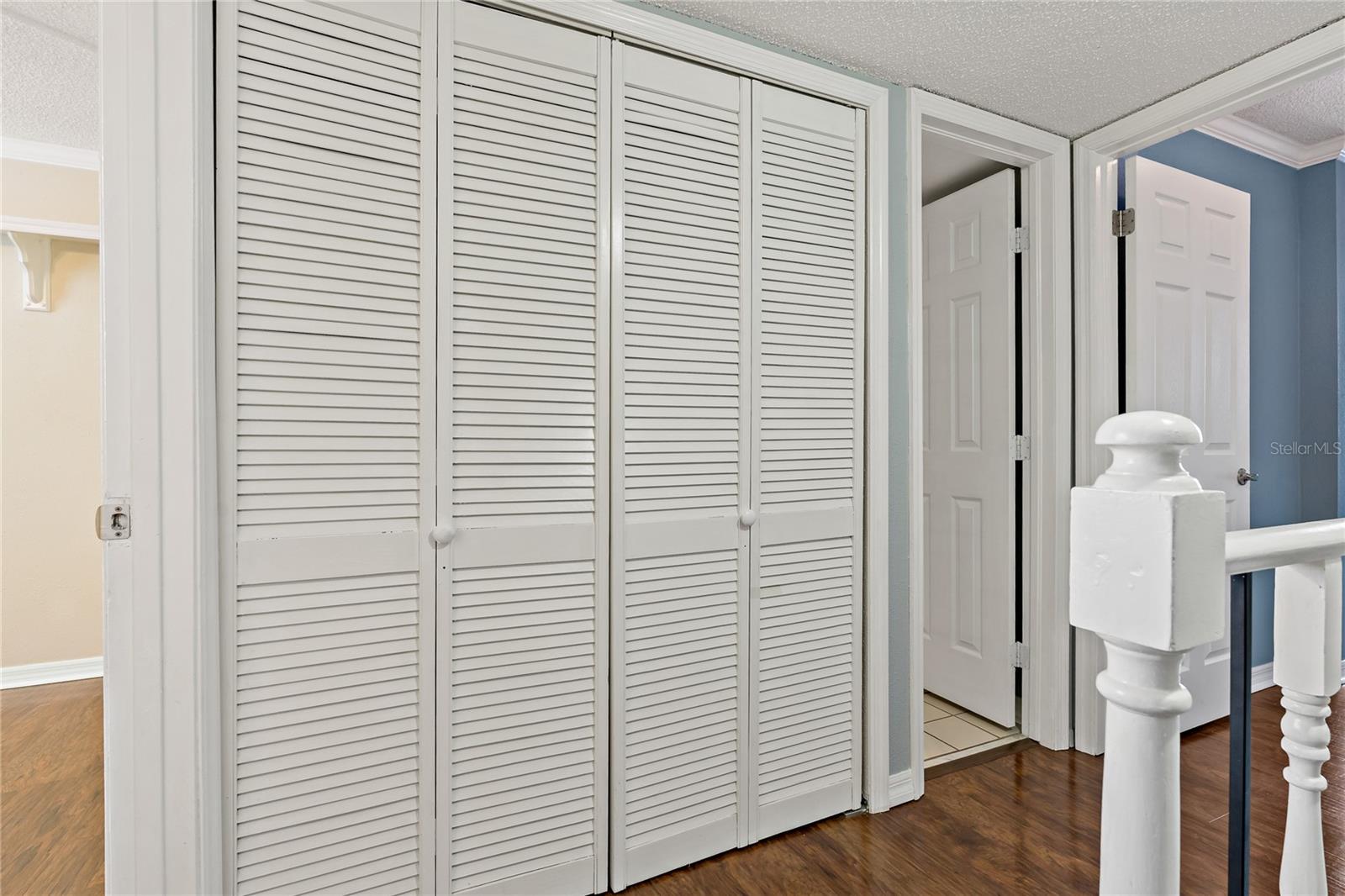 Stair Landing area with view of Guest Bedroom on left, Hall Closet, Bathroom Door and Primary Bedroom Door on Right