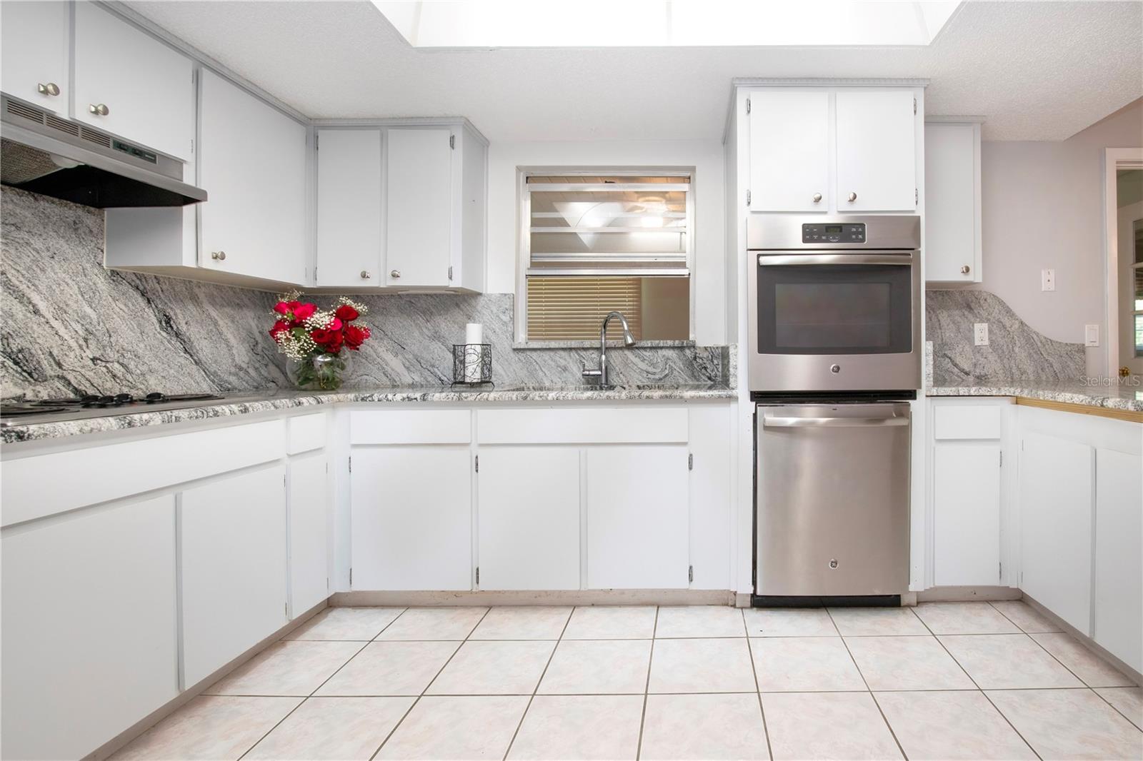 view of kitchen with serving window to enclosed lanai