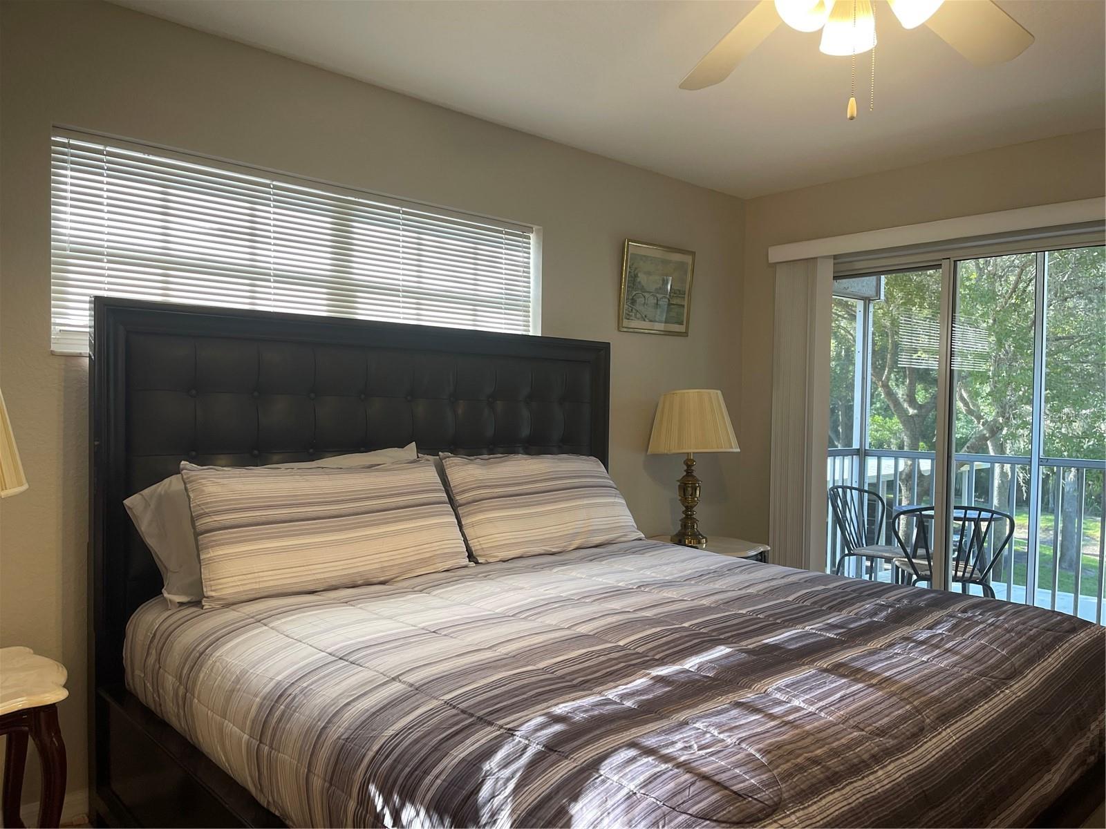 Primary bedroom with private screened balcony.