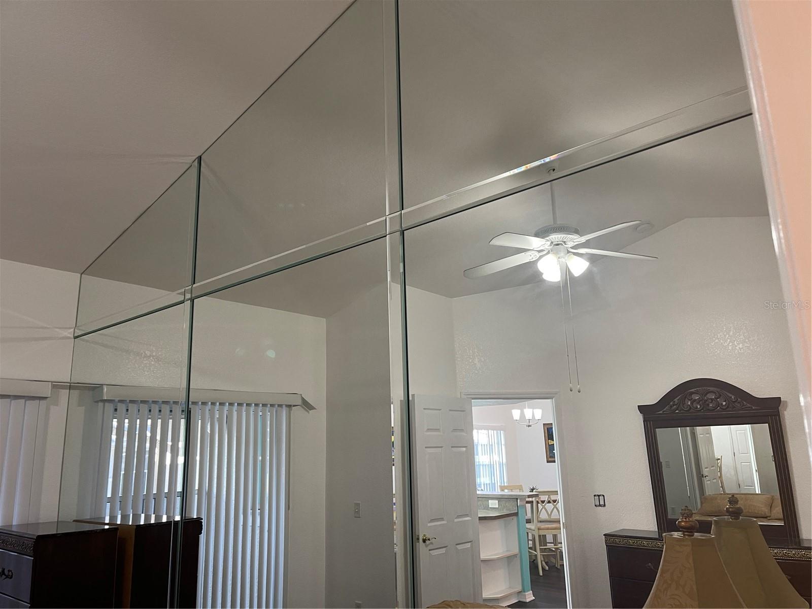 Mirrors go all the way up to the cathedral ceiling in primary bedroom