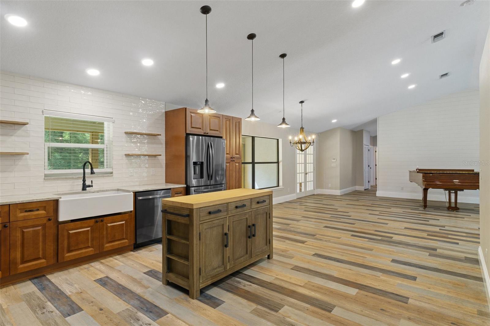 Kitchen flows to dining area and living room to right of piano.