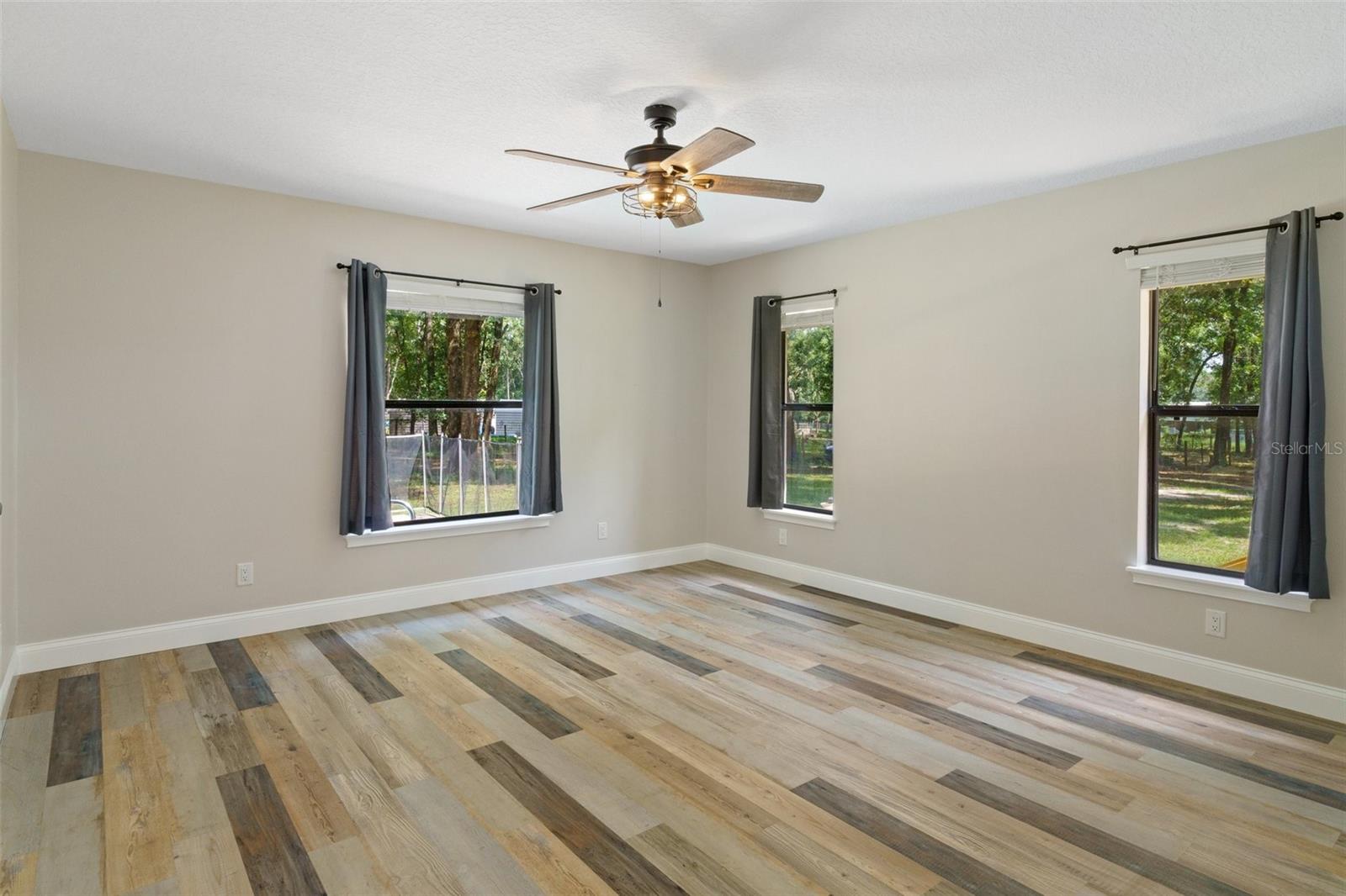 Primary bedroom with natural light entering from 3 windows.  Your big furniture or bedroom comfy chair will fit in this 15 x 14 space.