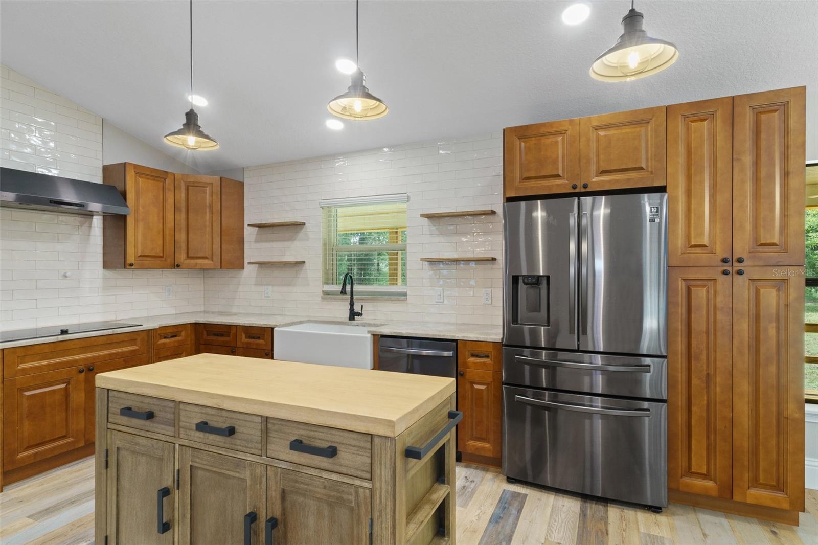 Volume ceilings, spot lighting and lots of windows bring brightness to kitchen and rest of the home.