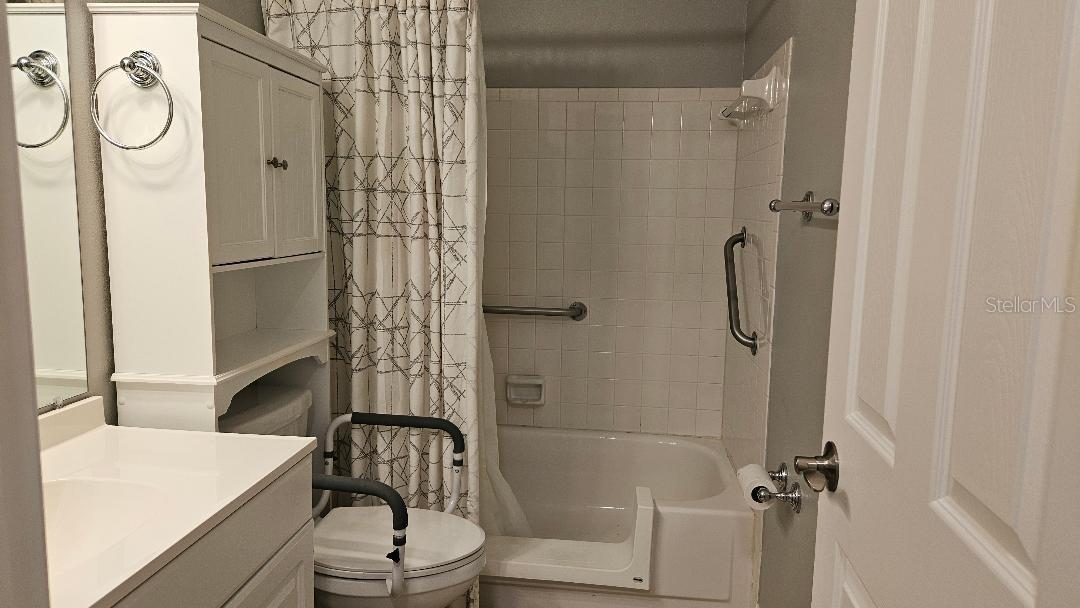 Bathroom with hand rails and cut out for easy access.