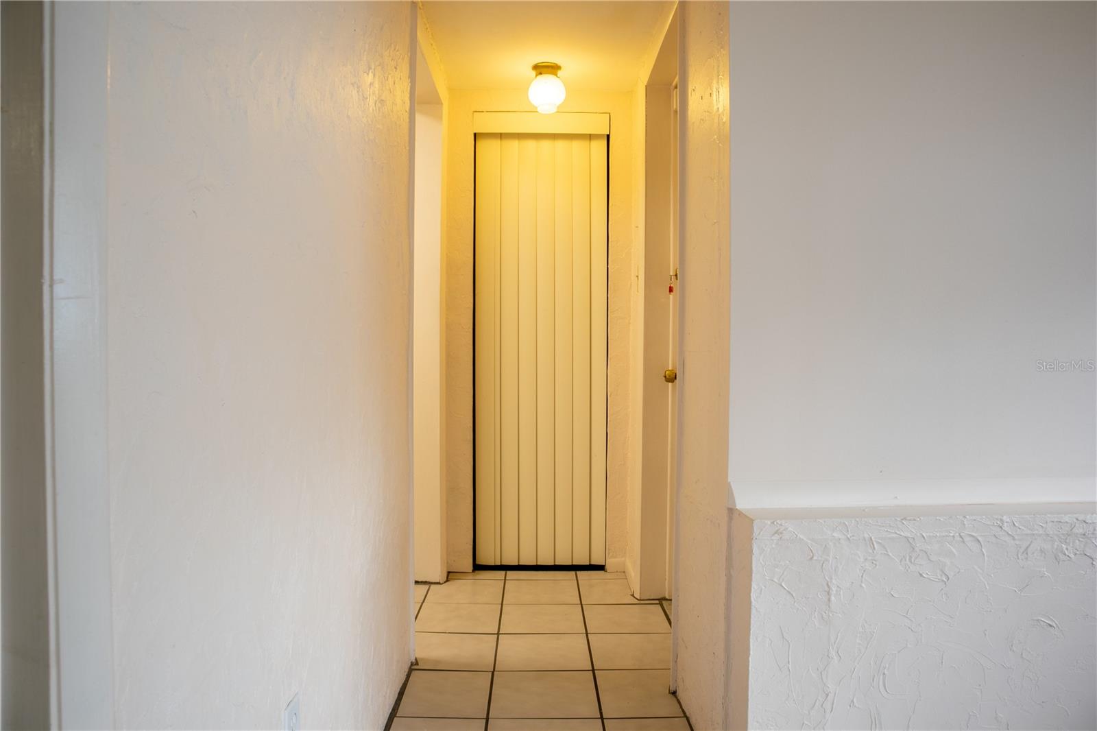 Hallway from the family room leading to the guest bath and the back yard .