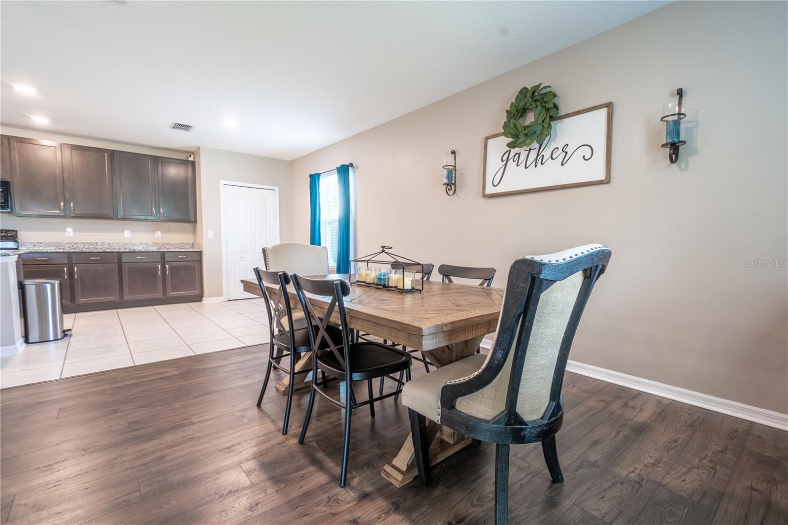 The dining room features wood laminate flooring and is open to the kitchen.