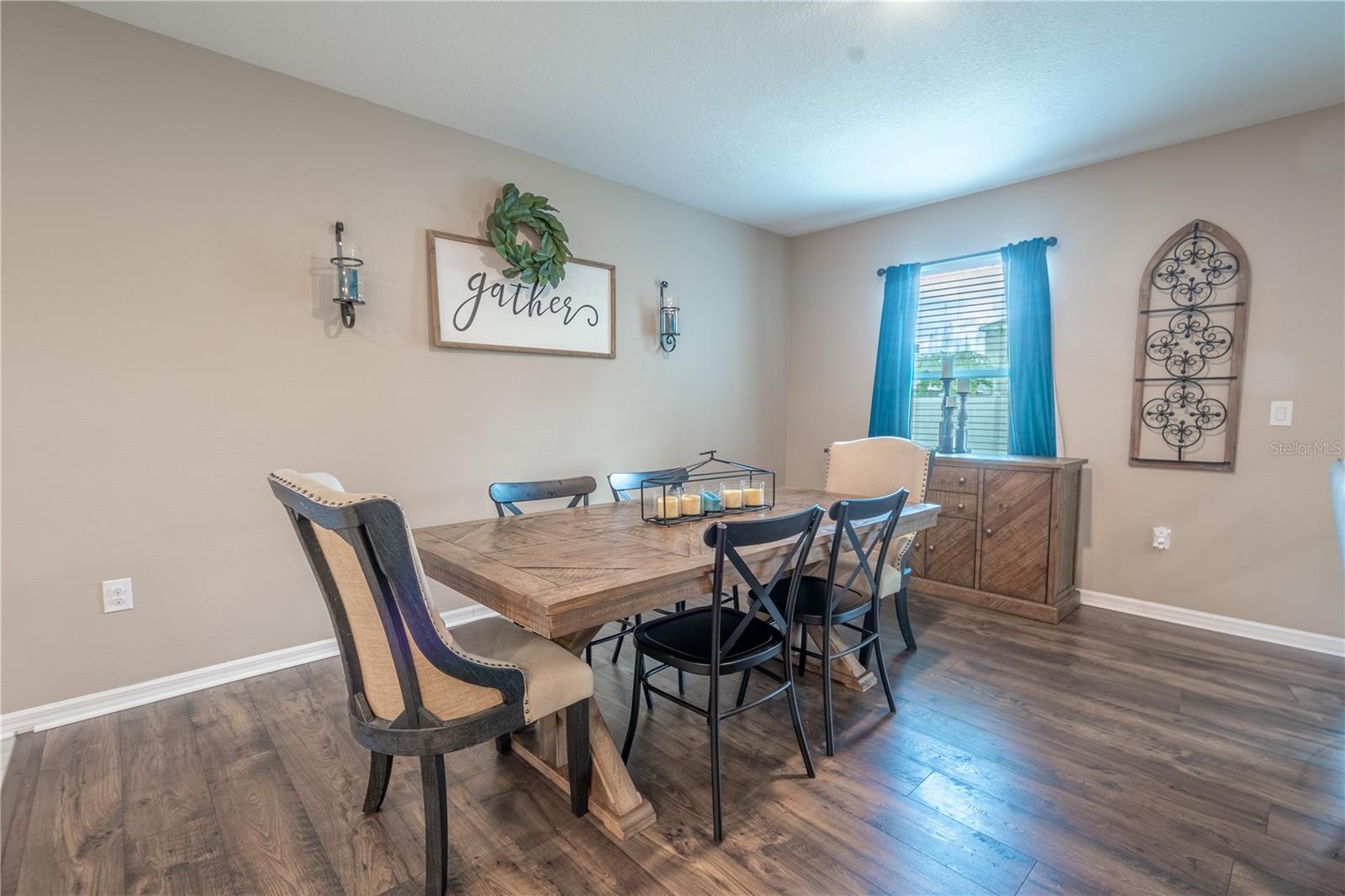 The natural light dances across the table, casting a gentle glow on the walls.dining room.