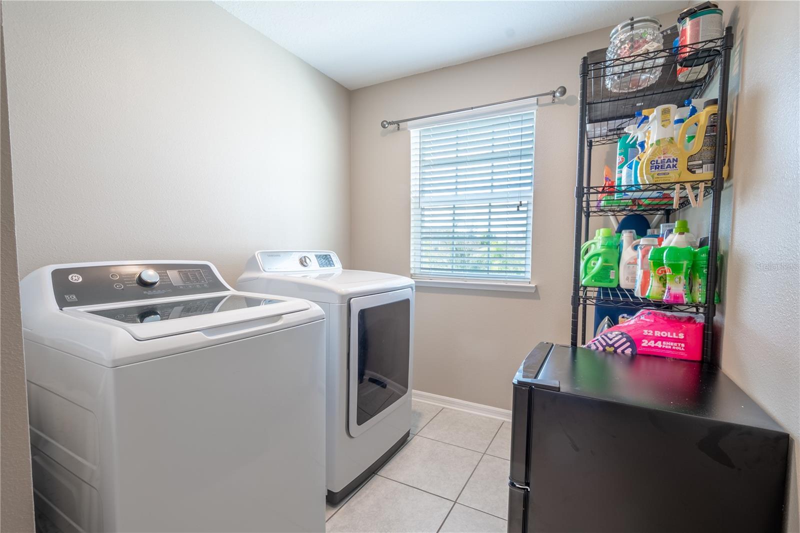 The laundry room features ceramic tile flooring , a GE washer and a Samsung dryer.