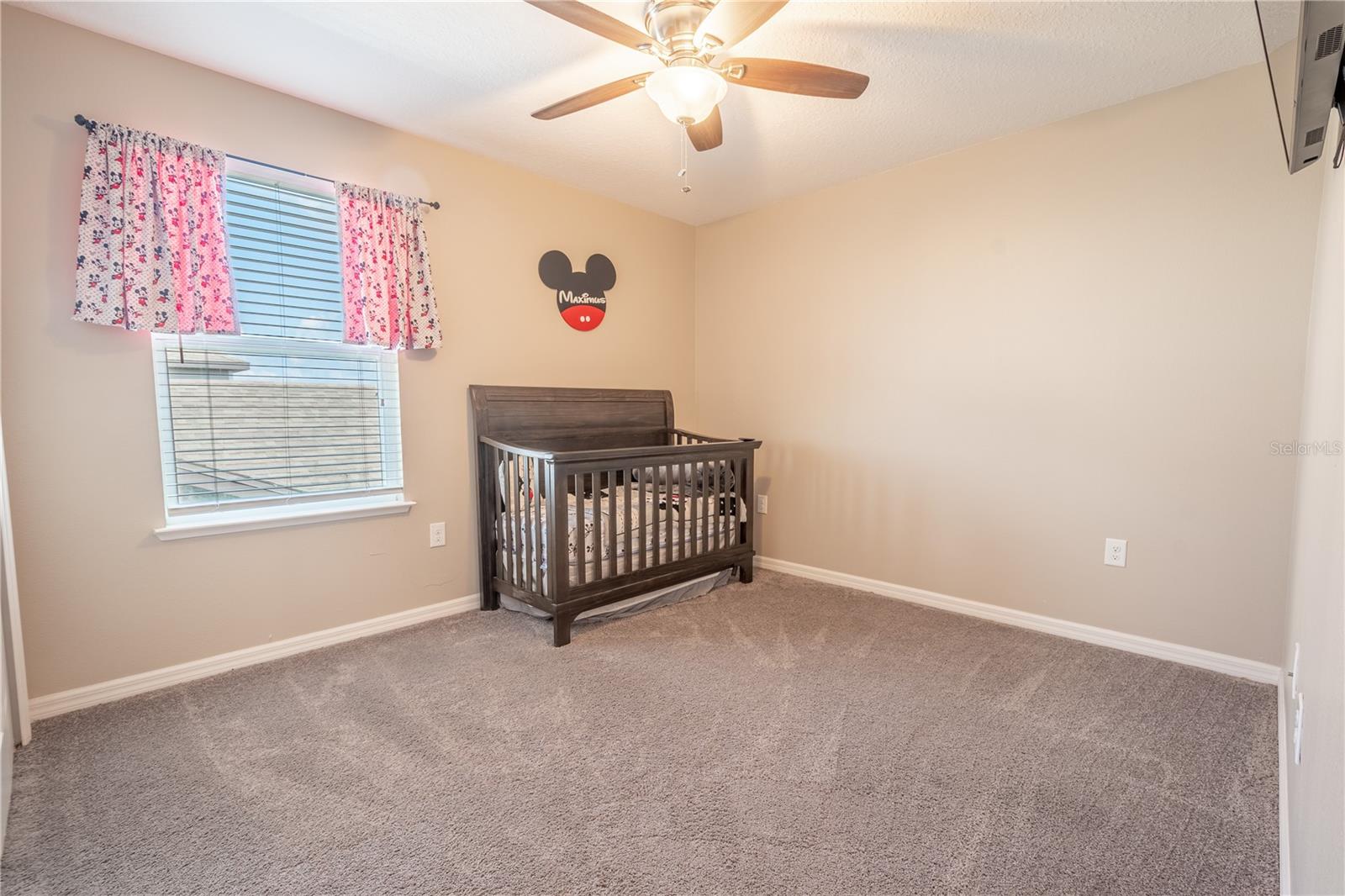 Bedroom Four features plush neutral tone carpet, a built-in closet, and a ceiling fan with light kit.