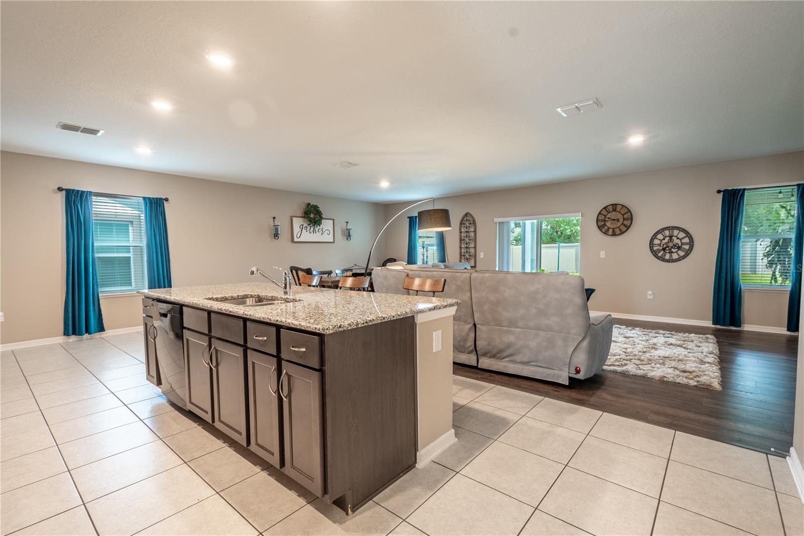 The kitchen is open to the dining and living room. The kitchen island features granite countertops, a stainless steel sink, a GE dishwasher, cabinets and drawers for additional storage and a breakfast bar.