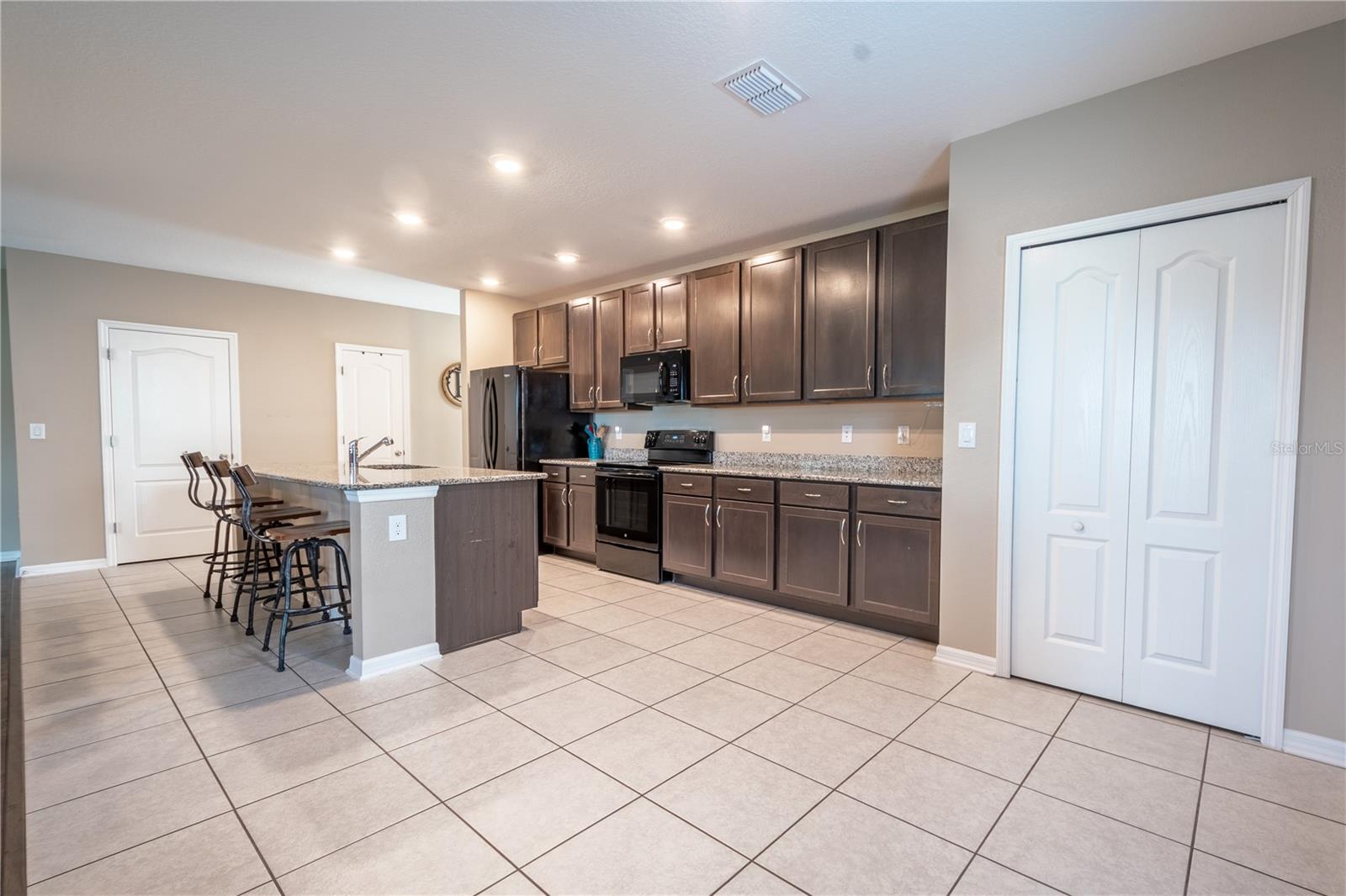 The kitchen is spacious, with a closet pantry for additional storage.