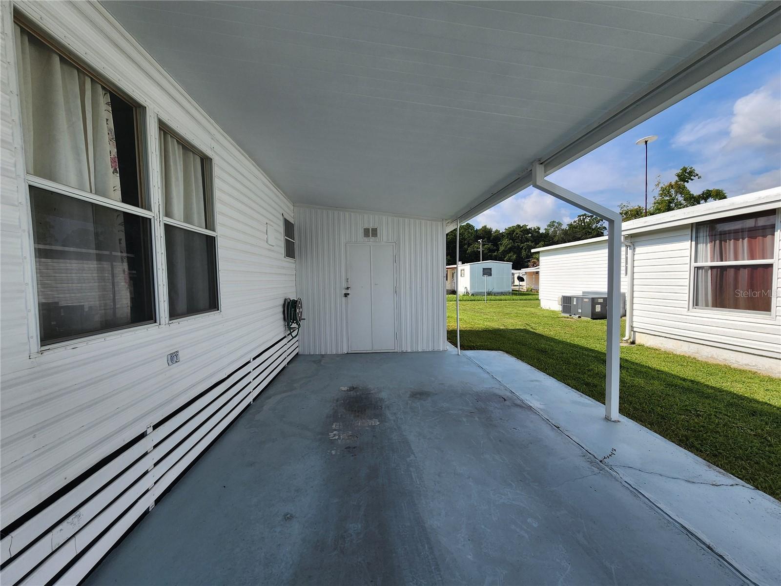 Carport & attached utility room with washer/dryer.