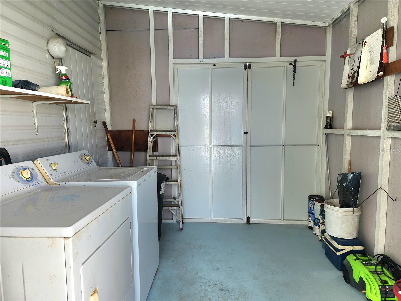 Attached utility room with washer/dryer & double door for golf cart parking.