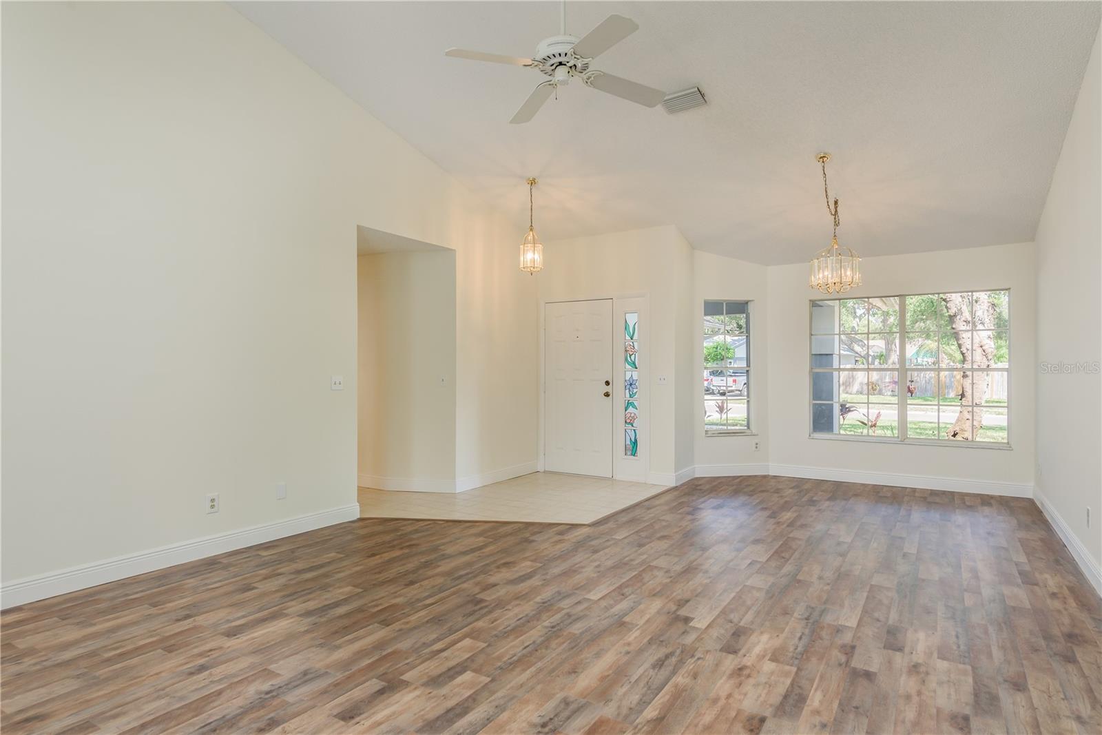 View of Great room of front door and windows with ceiling fan