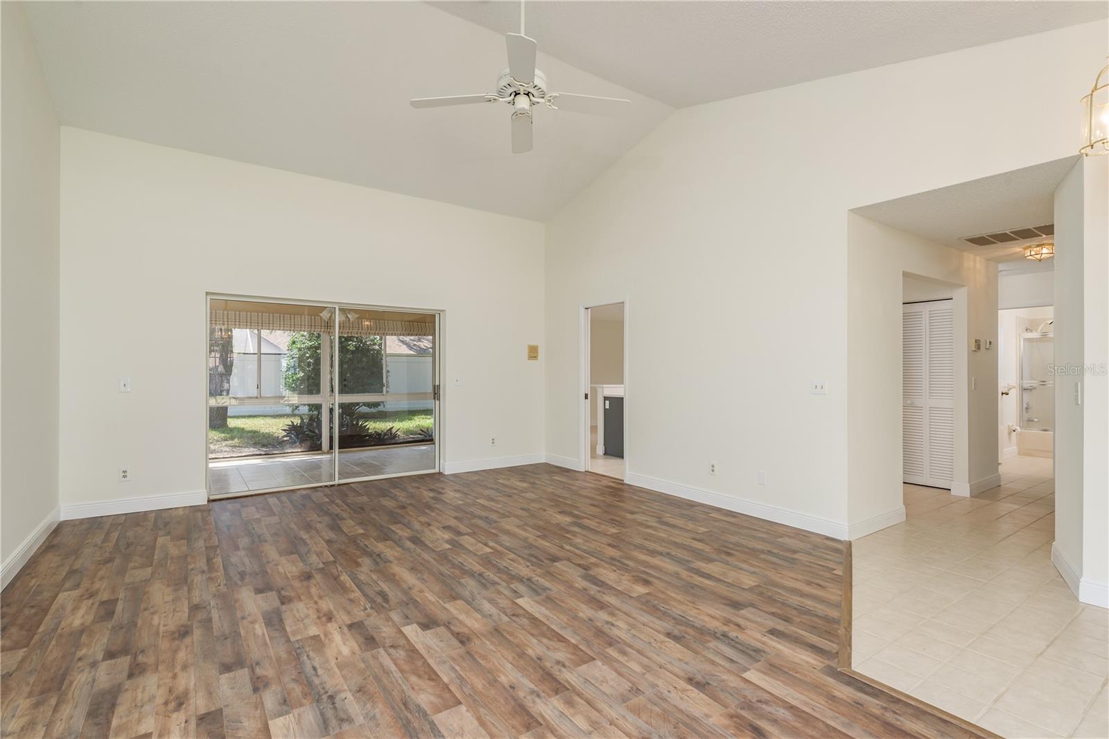 Great room view showing Florida room, doors to kitchen and hallway