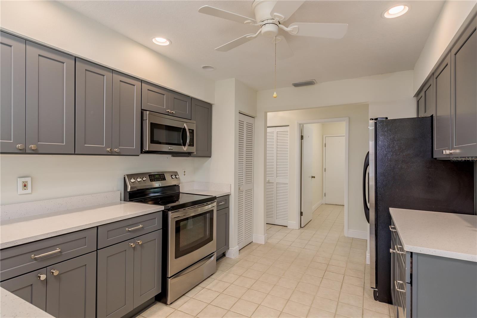 Kitchen view from breakfast bar through to hall leading to laundry room