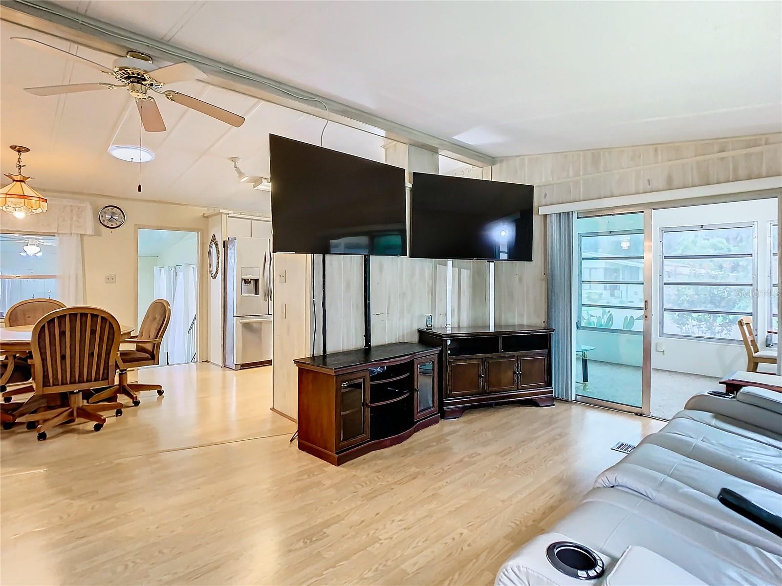 Living room connects to dining/kitchen and enclosed sunroom.