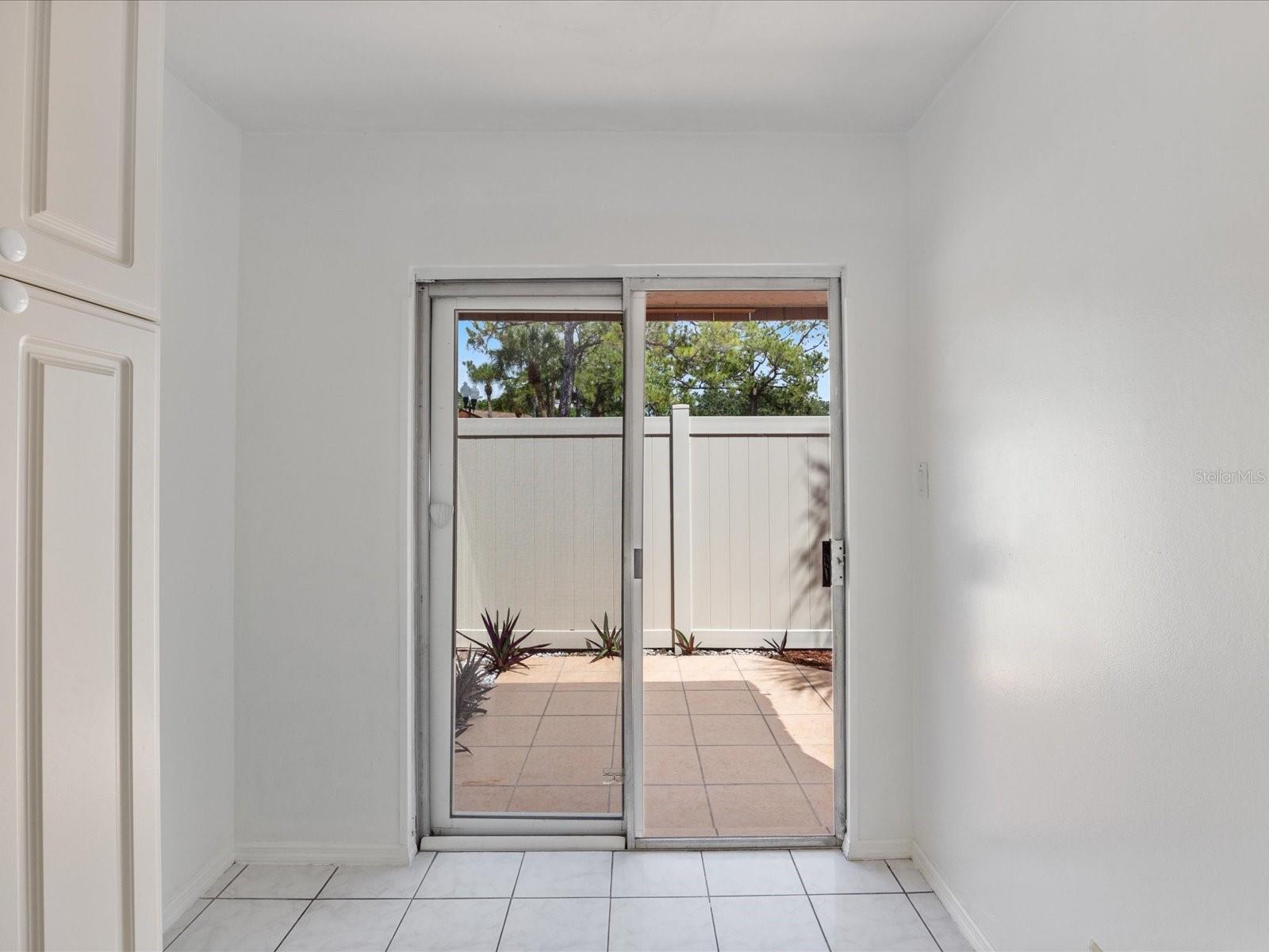 Sliding glass doors in eat-in kitchen leading to front patio