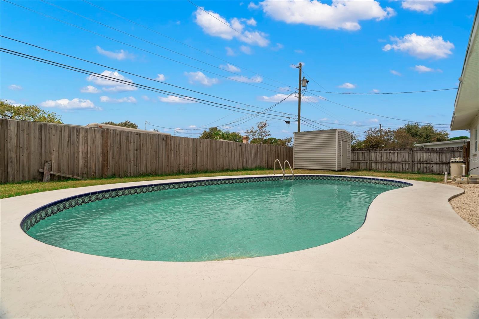 Backyard with chlorine, in-ground pool, and shed.