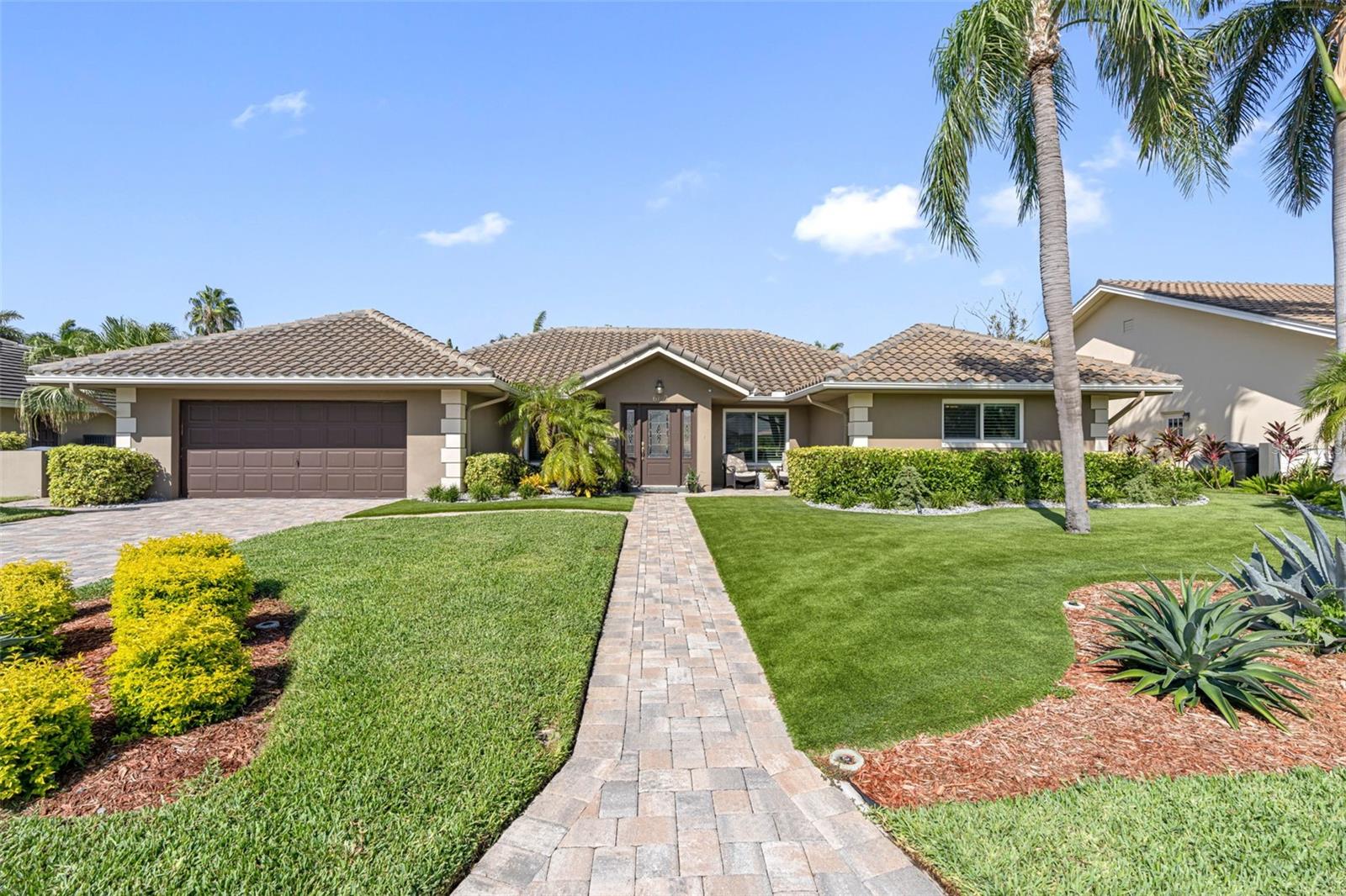 Tropical landscaping, spacious layout, and curb appeal characterize this inviting home.