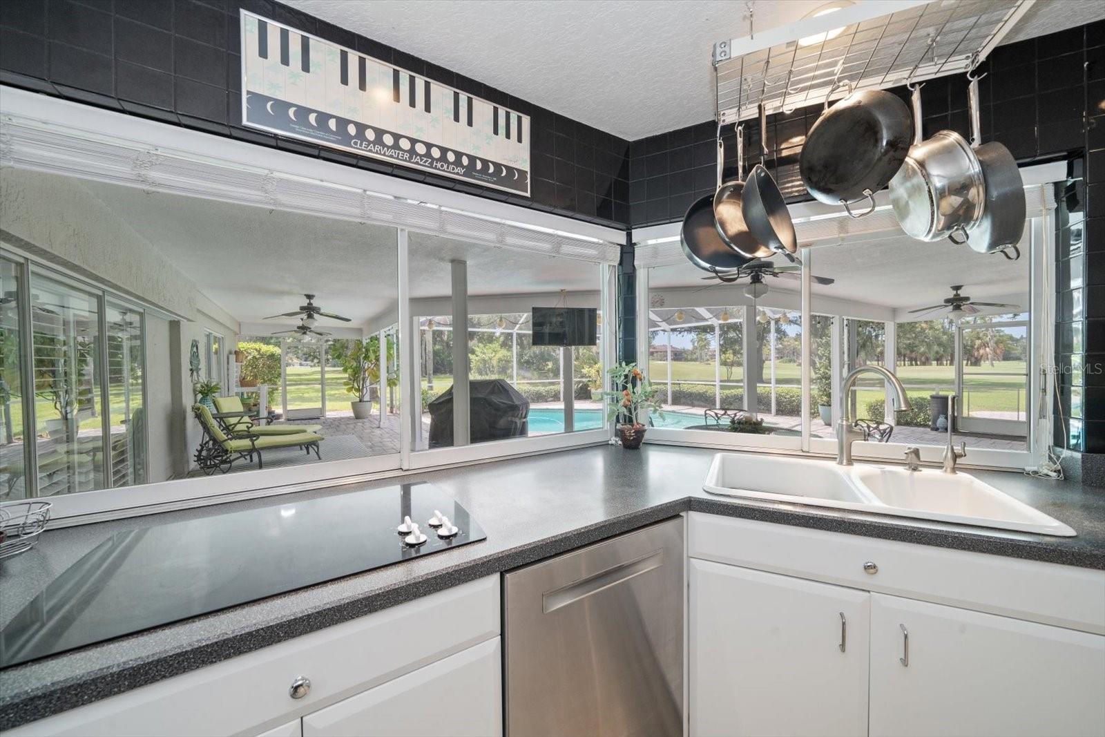 View of the back patio and pool form the kitchen with sliding windows