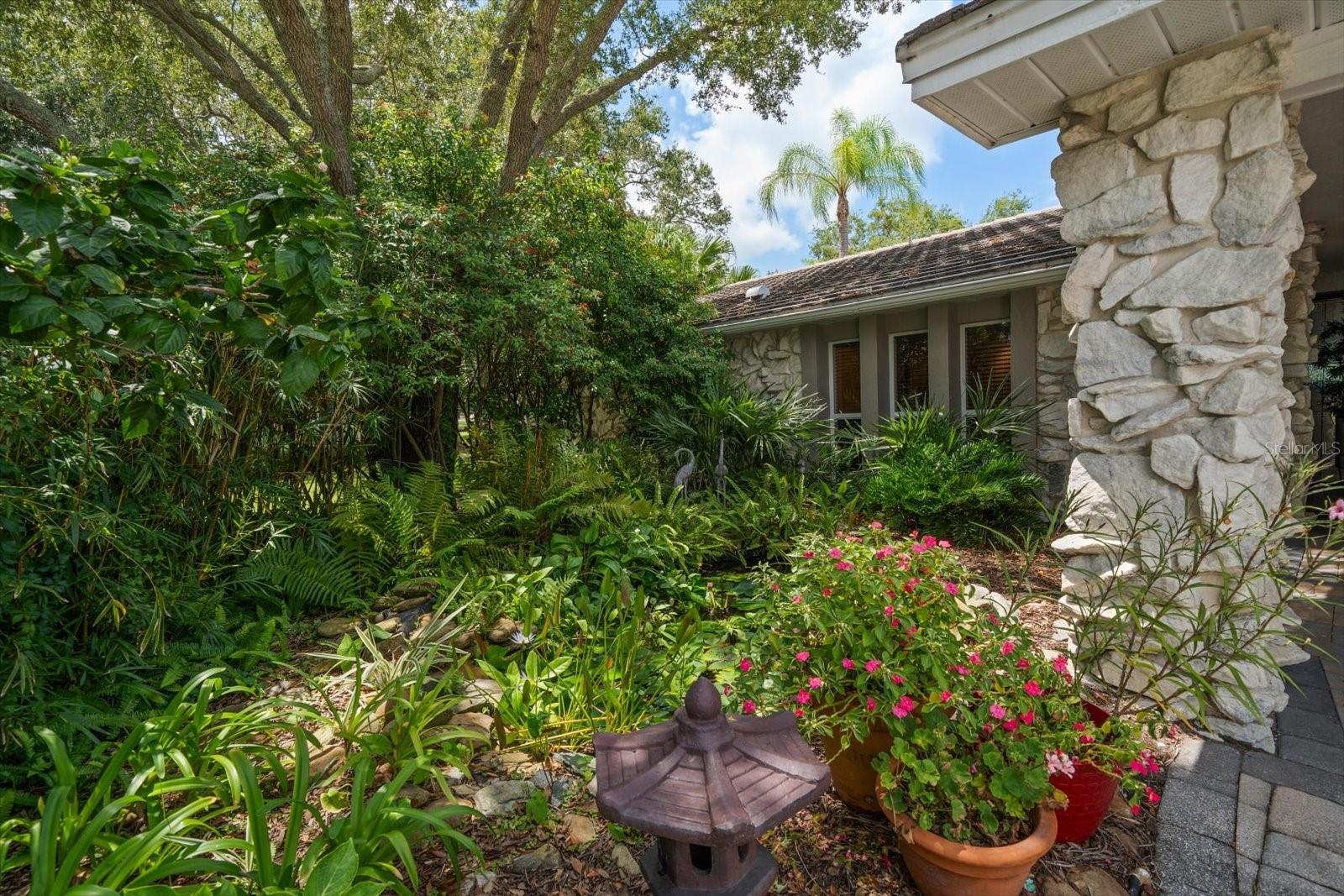 Beautiful butterfly garden and koi pond at the front entry to the home.