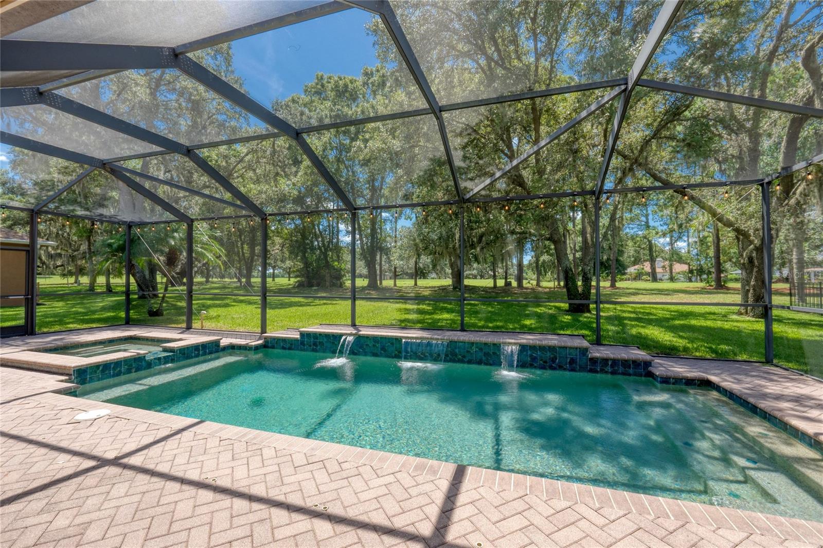 Large, screened in heated pool with waterfall